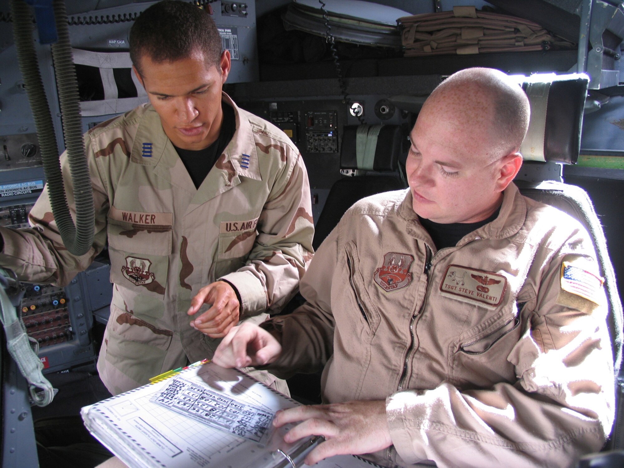 SOUTHWEST ASIA -- EDITOR'S NOTE:  CADET WALKER DID NOT FLY ABOARD THIS MISSION.  Technical Sergeant Steve Valenti (right) briefs Cadet First Class James Walker about the take-off parameters of a C-130 Hercules before an airlift mission to Iraq.  Cadet Walker and 18 of his US Air Force Academy classmates are at a forward deployed location participating in Operation Air Force.  Ops Air Force is a 30-day program that allows USAFA cadets to gain first-hand knowledge of the operational Air Force.  (U.S. Air Force photo) 