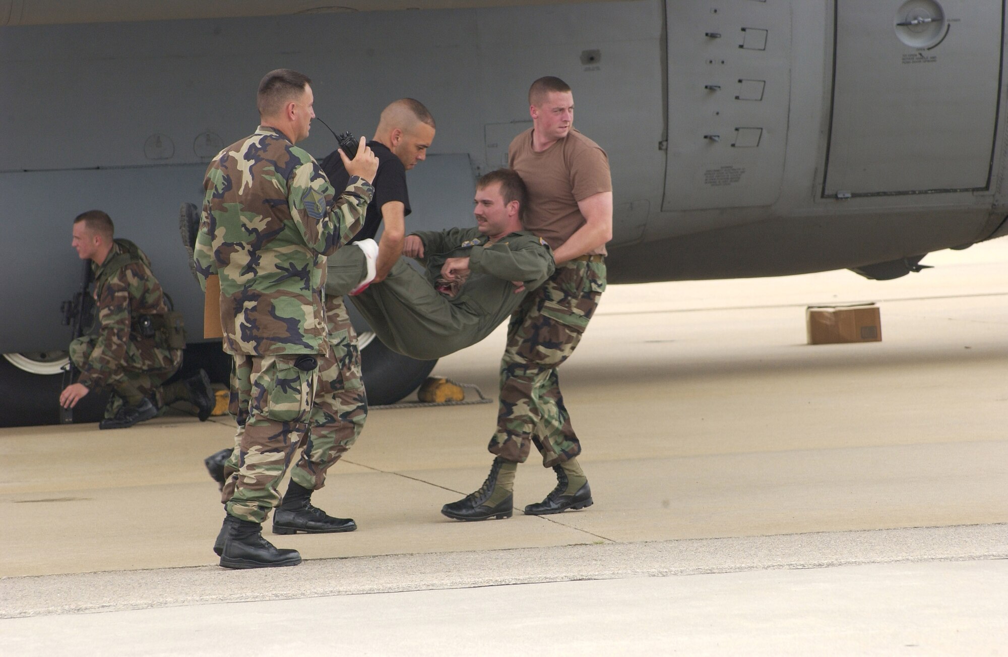 Members of the 43rd Security Forces Squadron carry a ?wounded? aircrew member out of harms way during a hijacking exercise July 25. In the exercise, the aircrew was held hostage while the 43rd SFS worked to negotiate with their captives. As part of the exercise, the hijackers were also able to ?detonate? an explosive that took out the air traffic control tower and the fire department. This led to the base integrating its resources with local Fayetteville and Fort Bragg authorities to get the base up and running again. The exercise helps the base prepare for any number of possible real-world scenarios. (U.S. Air Force photo/Dave Davenport)