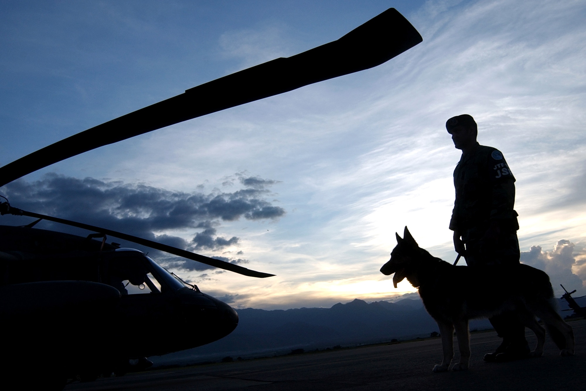 Staff Sgt. Rafael Melendez and Hoston patrol the flightline at Soto Cano Air Base, Honduras, Aug. 2. Sergeant Melendez and his military working dog provide direct support to Joint Task Force - Bravo and U.S. customs to prevent the illegal use and transport of narcotics through Central America. They also provide explosive detection for the safety of servicemembers, local nationals and visitors to Soto Cano. (U.S. Air Force photo/Senior Airman Mike Meares)