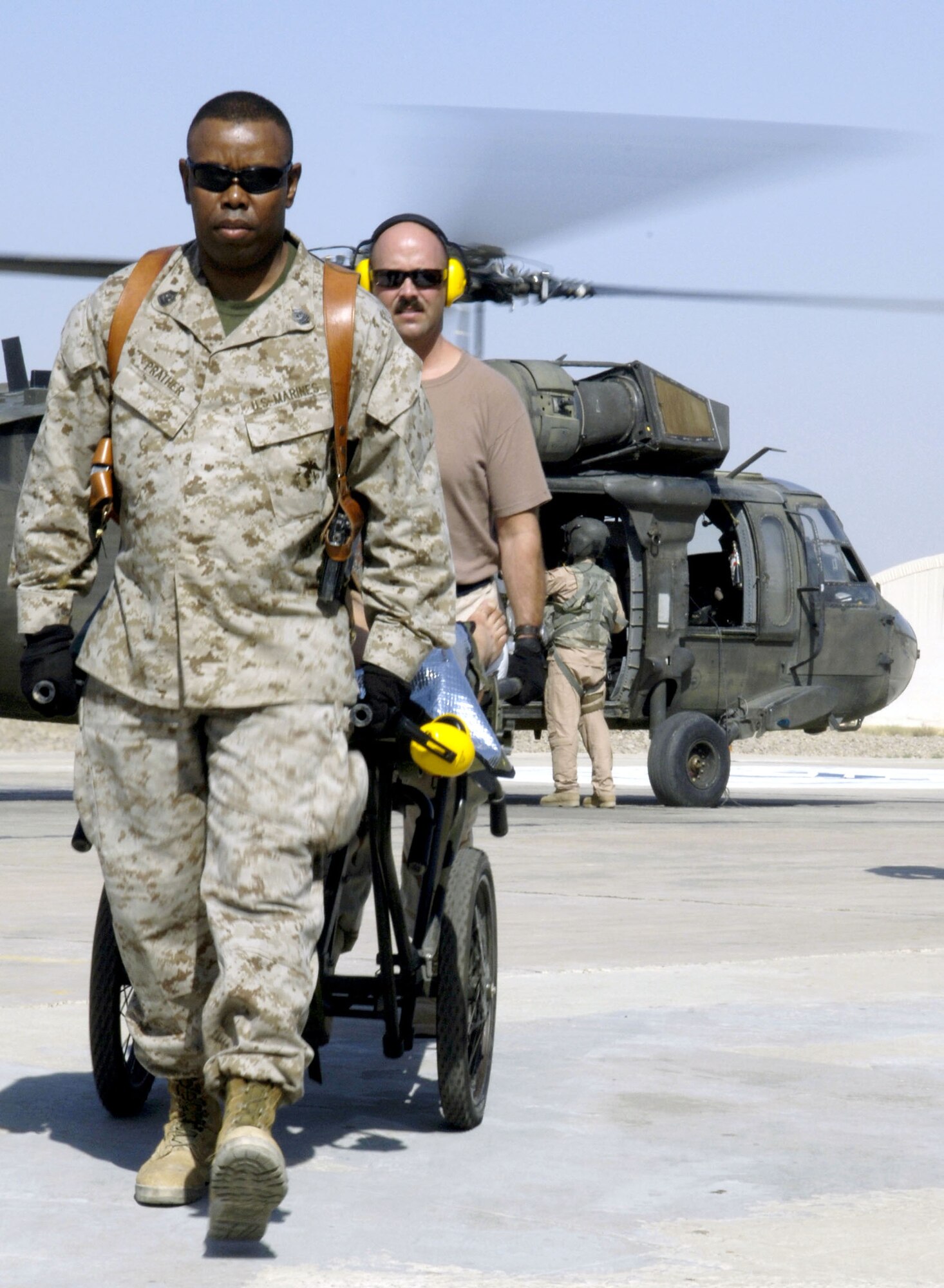 Master Gunnery Sgt. Timothy Prather and Master Sgt. Ronald Gustafson assist with unloading medevac passengers off a UH-60 Black Hawk at the Air Force Theater Hospital at Balad Air Base, Iraq, on Aug. 2. The hospital provides Level 1 trauma and specialized medical care. Sergeant Prather is with the 332nd Expeditionary Medical Group. (U.S. Air Force photo/Airman 1st Class Andrew Oquendo)
