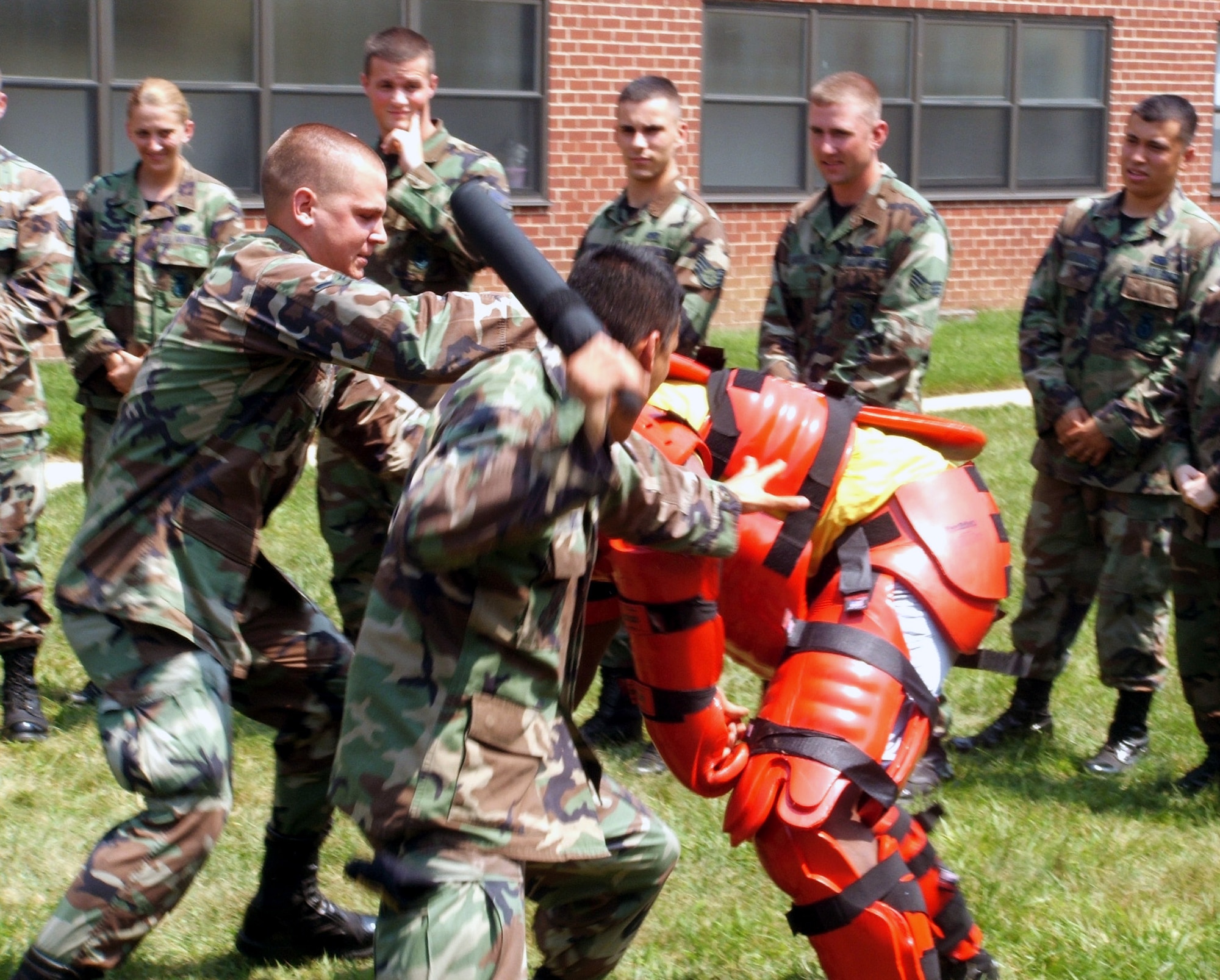 Airman 1st Class Guillermo Ortiz and Airman Coleman Powell participate in a training scenario with an aggressor in a "red man" suit during the Phoenix Raven course at Fort Dix, N.J., on Aug. 1. The course, taught by the Air Mobility Warfare Center's 421st Combat Training Squadron staff, trains security forces in use of force, anti-hijacking measures and aircraft security. Airman Ortiz is a security forces journeyman with the 437th Security Forces Squadron at Charleston Air Force Base, S.C. Airman Powell is a security forces journeyman from the 377th SFS at Kirtland AFB, N.M. (U.S. Air Force photo/Tech. Sgt. Scott T. Sturkol) 
