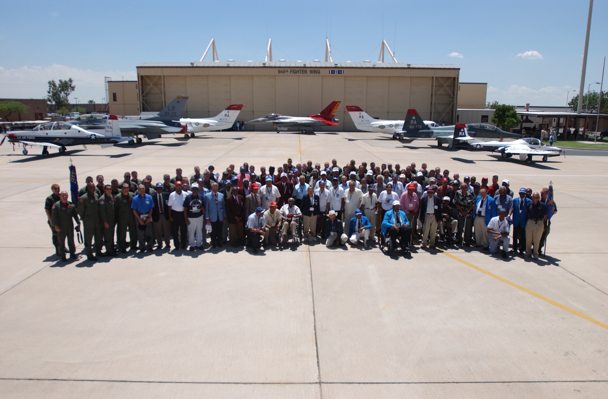 Members of the 99th, 100th, 301st and 302nd Fighter Squadrons pose with more than 50 original Tuskegee Airmen in front of airplanes painted with Tuskegee Airmen signature red tails. (U.S. Air Force photo/Senior Airman Christopher Hummel)                               