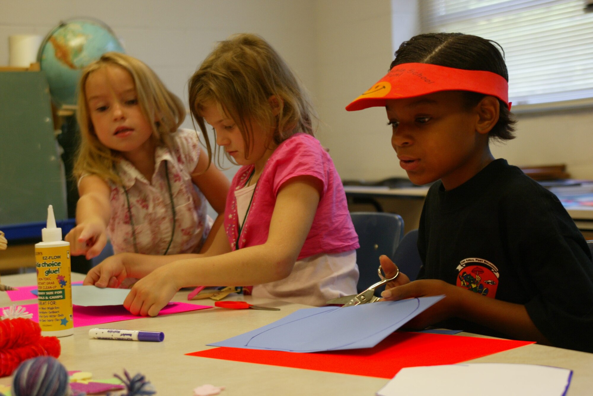 (Left to right) Brooklyn Fellure, Paychel Heim and Jayed Easter create tic-tac-toe boards July 21 at Pope's Vacation Bible School. The interfaith camp was held at no cost to the parents and aimed to bring families and the community closer together. (U.S. Air Force photo/Lisa Terry McKeown)