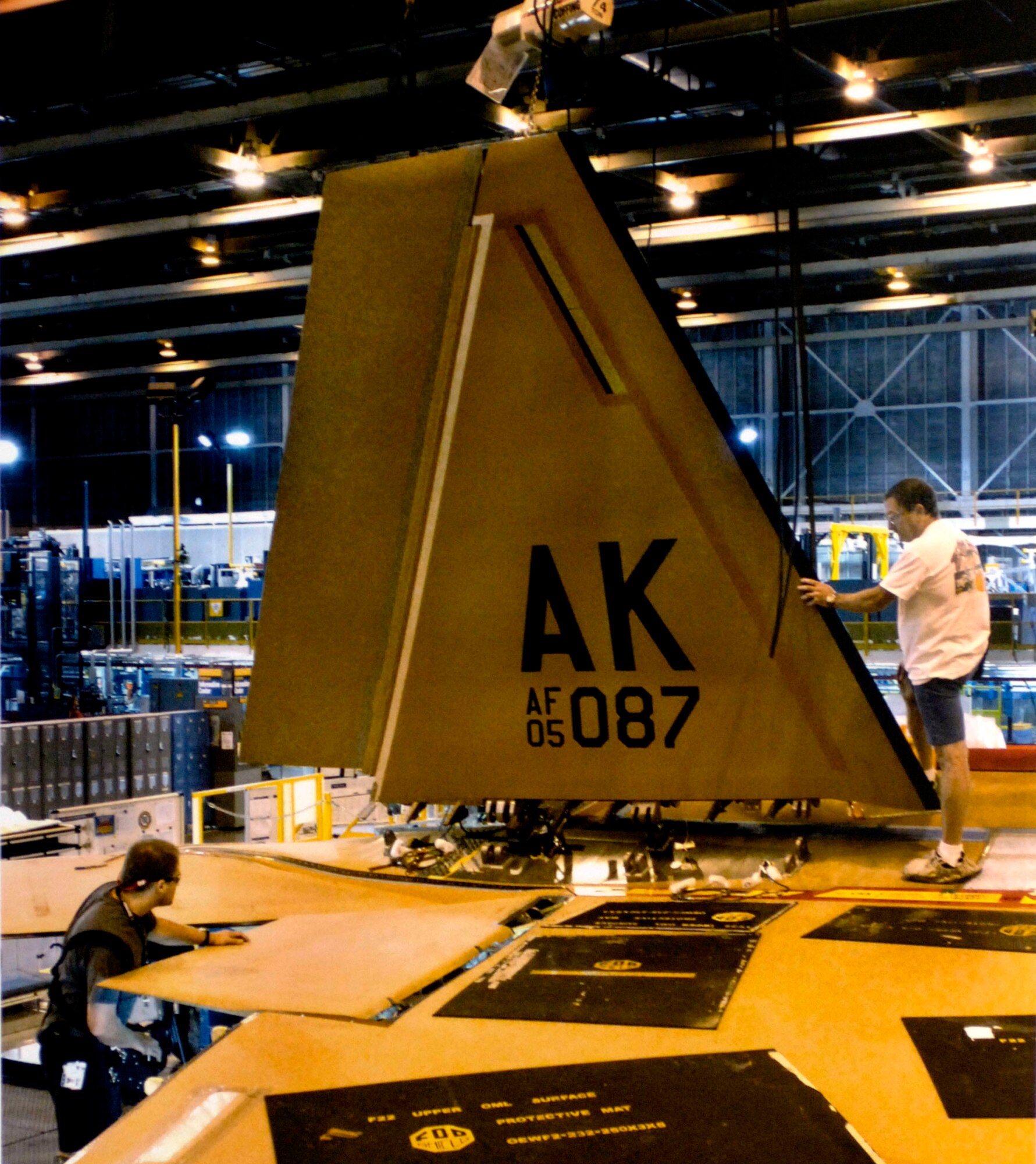 Employees at Lockheed Martin's F-22 Raptor production facility here attach a tail fin to the body of Raptor 4087.  The aircraft, the first to bear the "AK" tail flash, is destined for Elmendorf Air Force Base, Alaska.  It is the first of 36 Raptors that will be assigned to Pacific Air Forces. (Courtesy photo/Lockheed-Martin