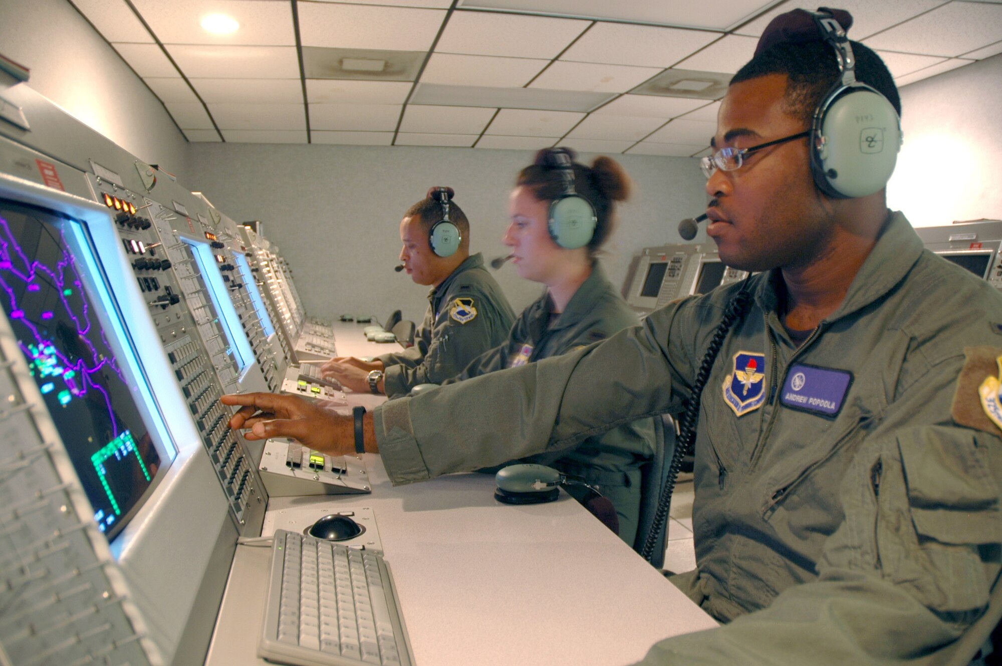 First Lts. Andrew Popoola, Renee Powell and Darin Romain practice sending free text messages at Tyndall Air Force Base, Fla., to F-22 Raptor pilots on July 27. The 325th Air Control Squadron trains all active duty, Guard and Reserve undergraduate air battle managers. The lieutenants are all air battle manager students. (U.S. Air Force photo/1st Lt. Jon Quinlan) 