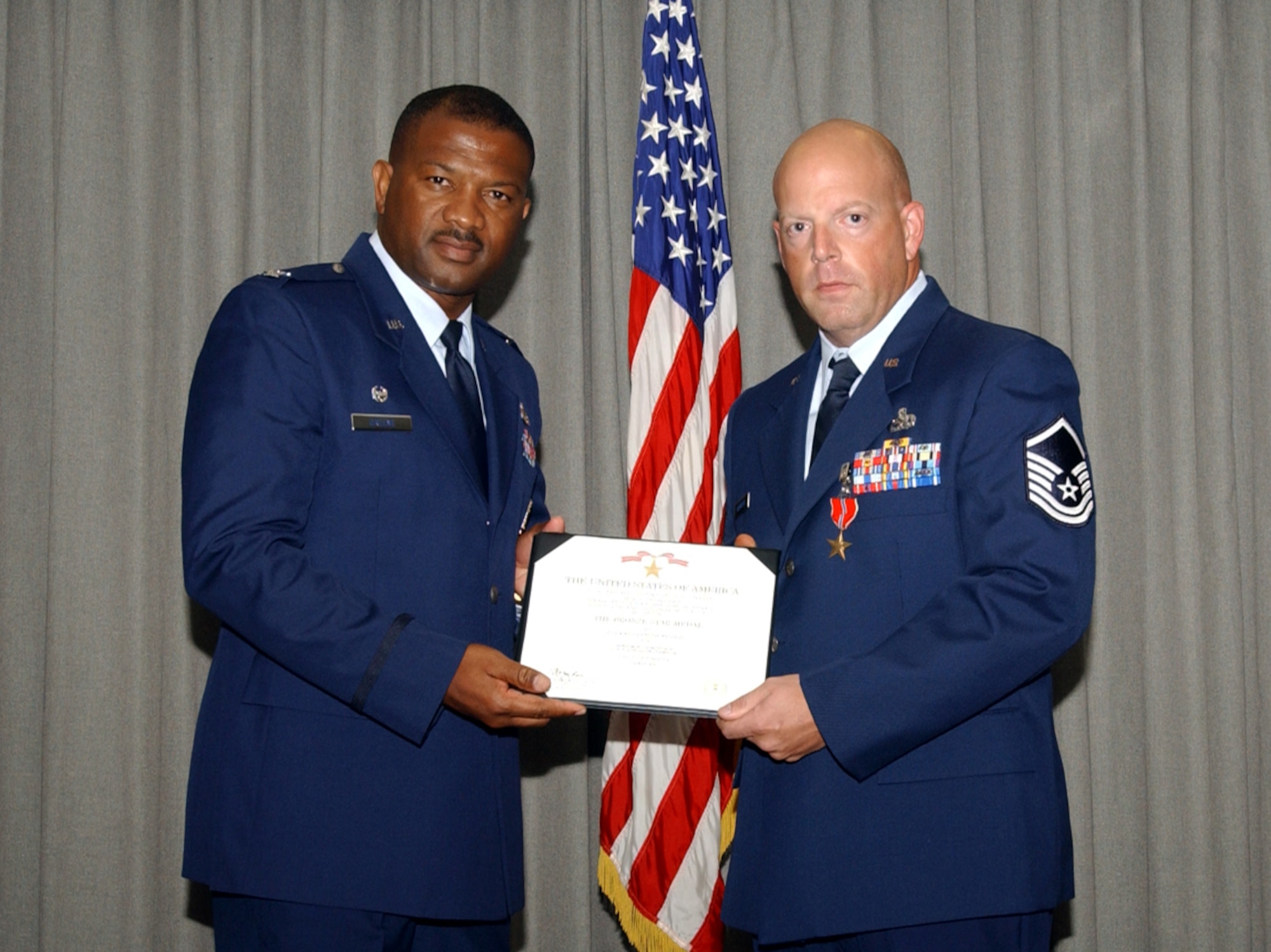Col. Socrates Greene (left), 16th Maintenance Group commander, presents a Bronze Star to Master Sgt. David Halvorson, 16th Helicopter Maintenance Squadron MH-53 PAVE LOW production superintendent, in the 20th Special Operations Squadron July 27. (U.S. Air Force Photograph by Airman 1st Class Stephanie Sinclair) 