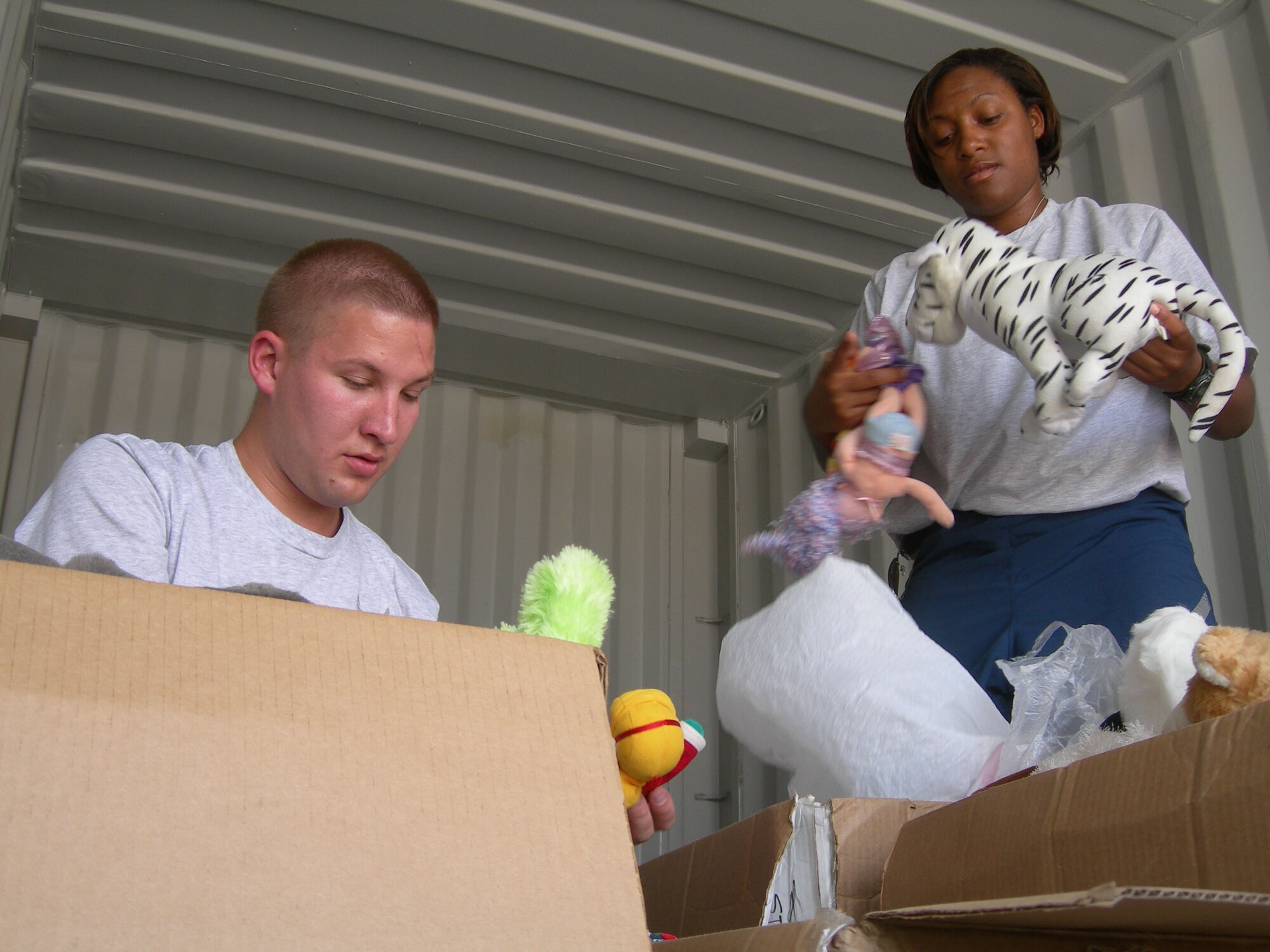 Staff Sgts. Scott Klobucher and Samantha Ross sort through boxes of donated toys at Balad Air Base, Iraq. (U.S. Air Force photo/2nd Lt. Lisa Kostellic)
