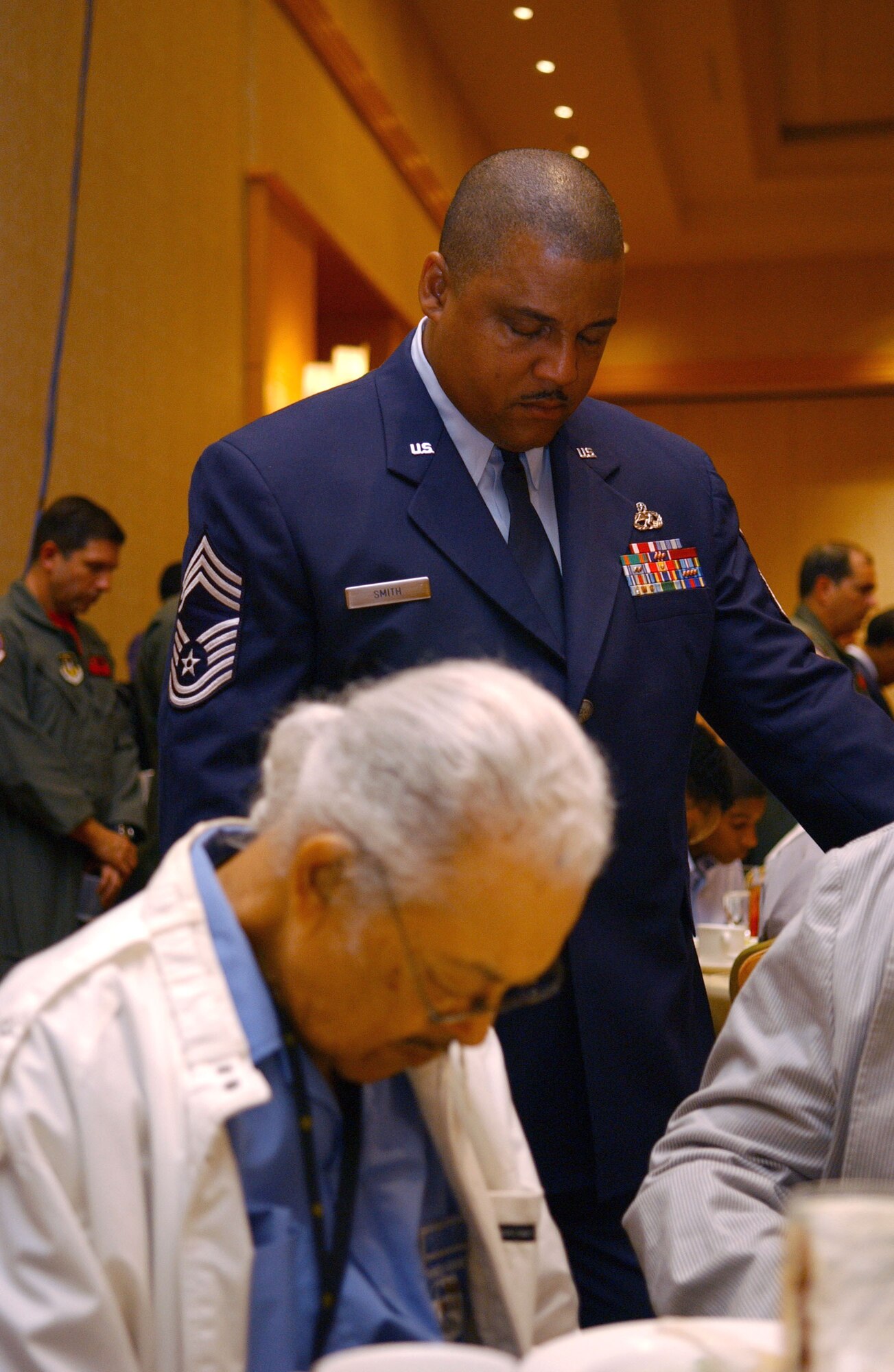 Chief Master Sgt. Joseph Smith and Tuskegee Airman Bill Thompson bow their heads during an invocation at a luncheon in Phoenix on Aug. 3. The event was part of the Tuskegee Airmen, Inc., 35th Annual National Convention. The organization exposes minority youth to aviation and aerospace technology. Chief Smith is with the 445th Maintenance Squadron at Wright-Patterson Air Force Base, Ohio. Mr. Thompson was a gunner with the 477th Bomb Group. (U.S. Air Force photo/Senior Airman Francisco V. Govea II)
