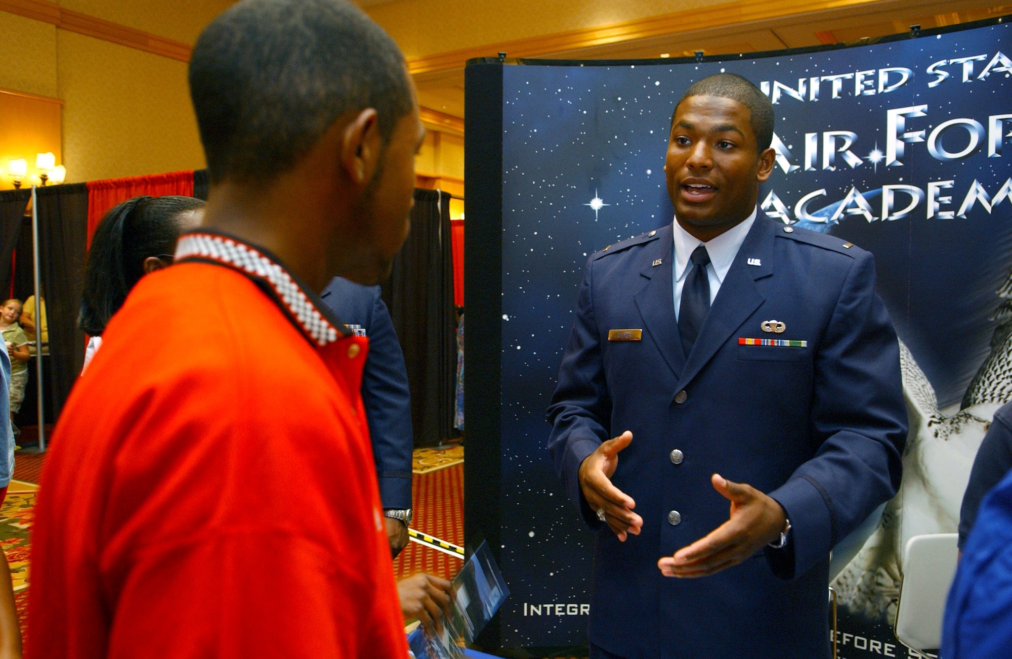 Second Lt. Jarod Gilmer speaks with Isaiah Steele of Surprise, Ariz., about the Air Force Academy during the Tuskegee Airmen, Inc., 35th Annual National Convention in Phoenix on Aug. 3. The organization exposes minority youth to aviation and aerospace technology. Lieutenant Gilmer is an academy admission adviser. (U.S. Air Force photo/Senior Airman Francisco V. Govea II)
