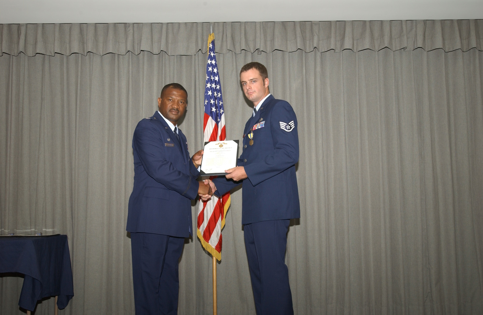 Col. Socrates Greene (left), 16th Maintenance Group commander, presents Staff Sgt. Sean Allen, 16th HMXS, the Air Force Commendation medal with valor July 27. (U.S. Air Force Photograph by Airman 1st Class Stephanie Sinclair)