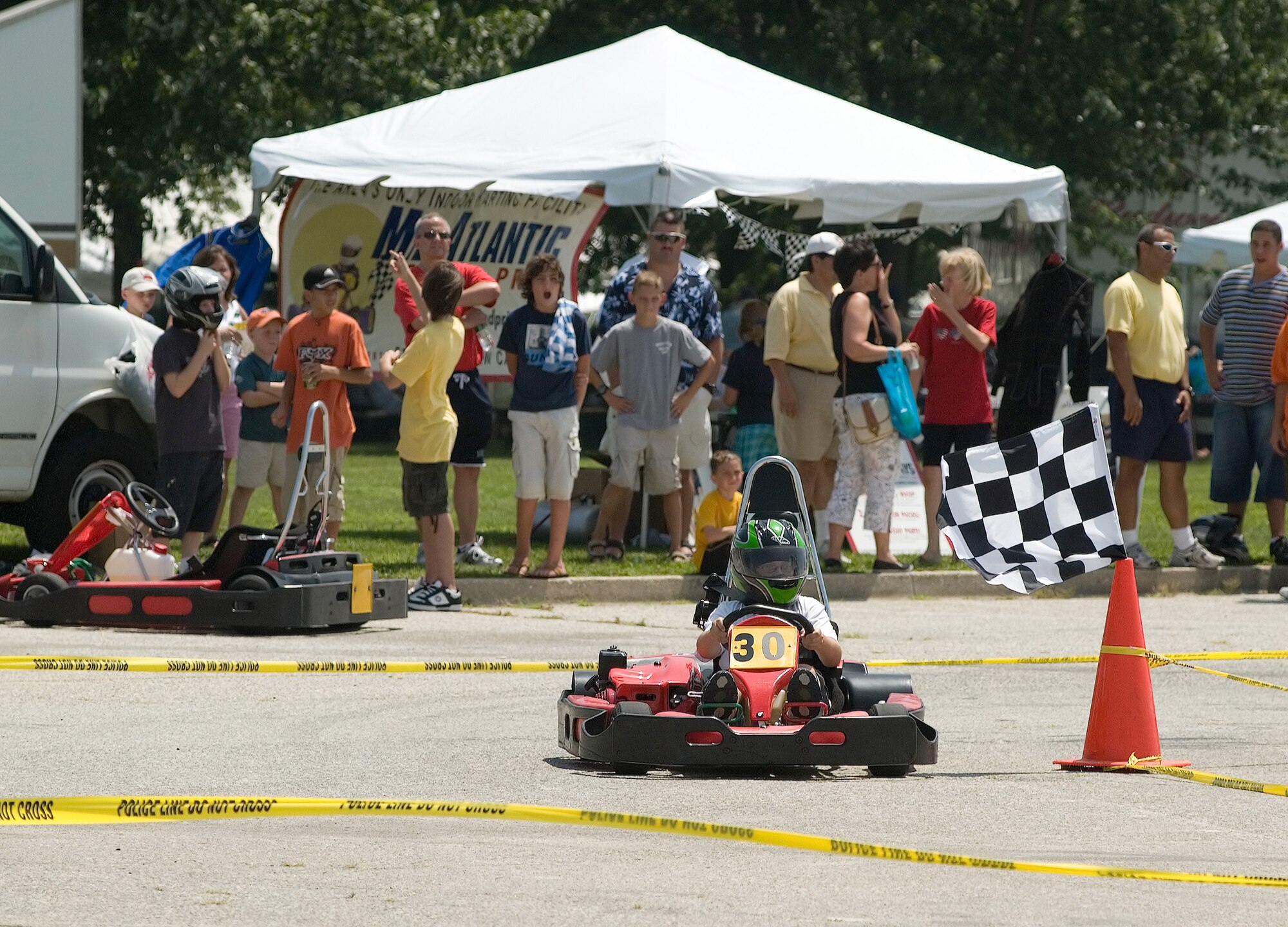 A Dover Team family member zooms around the temporary speedway at the 436th Airlift Wing picnic July 28 at Dover Air Force Base, Del. The picnic's line up also included live music from the local band Blind Inside, pony and hay rides, a travel expo and various other attractions. Visitors filled up on barbeque chicken, hamburger and hotdogs cooked and served by more than 75 volunteers. The annual event is a way for leadership to thank Dover members for their hard work and dedication throughout the year and increases morale. (U.S. Air Force photo/Jason Minto)