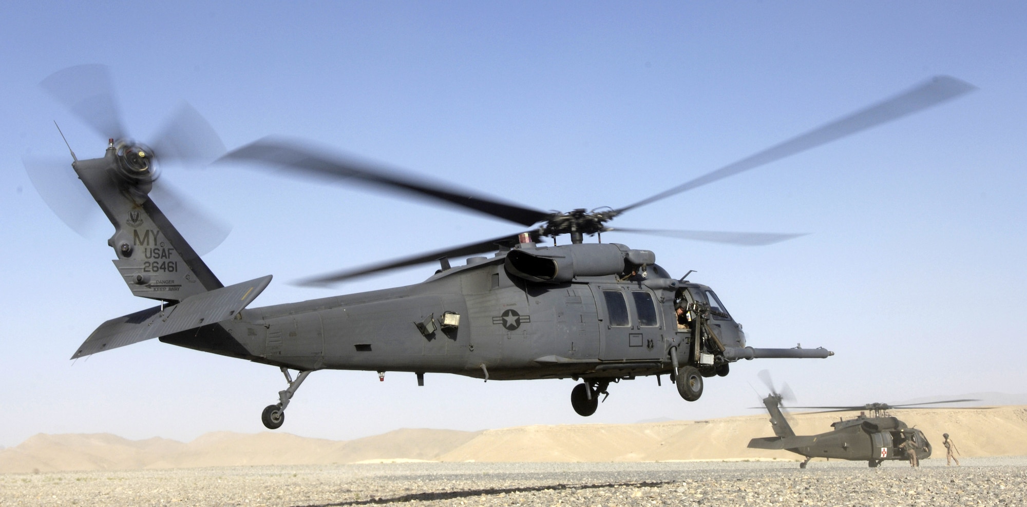 A Moody HH-60 Pave Hawk lands as an Army UH-60 Black Hawk prepares to pick up a patient at Kandahar, Afghanistan, June 13. Deployed Airmen from the 347th Operations Group recently combined their traditional combat search and rescue mission with a new medical evacuation mission. (U.S. Air Force photo/Senior Airman Brian Ferguson)