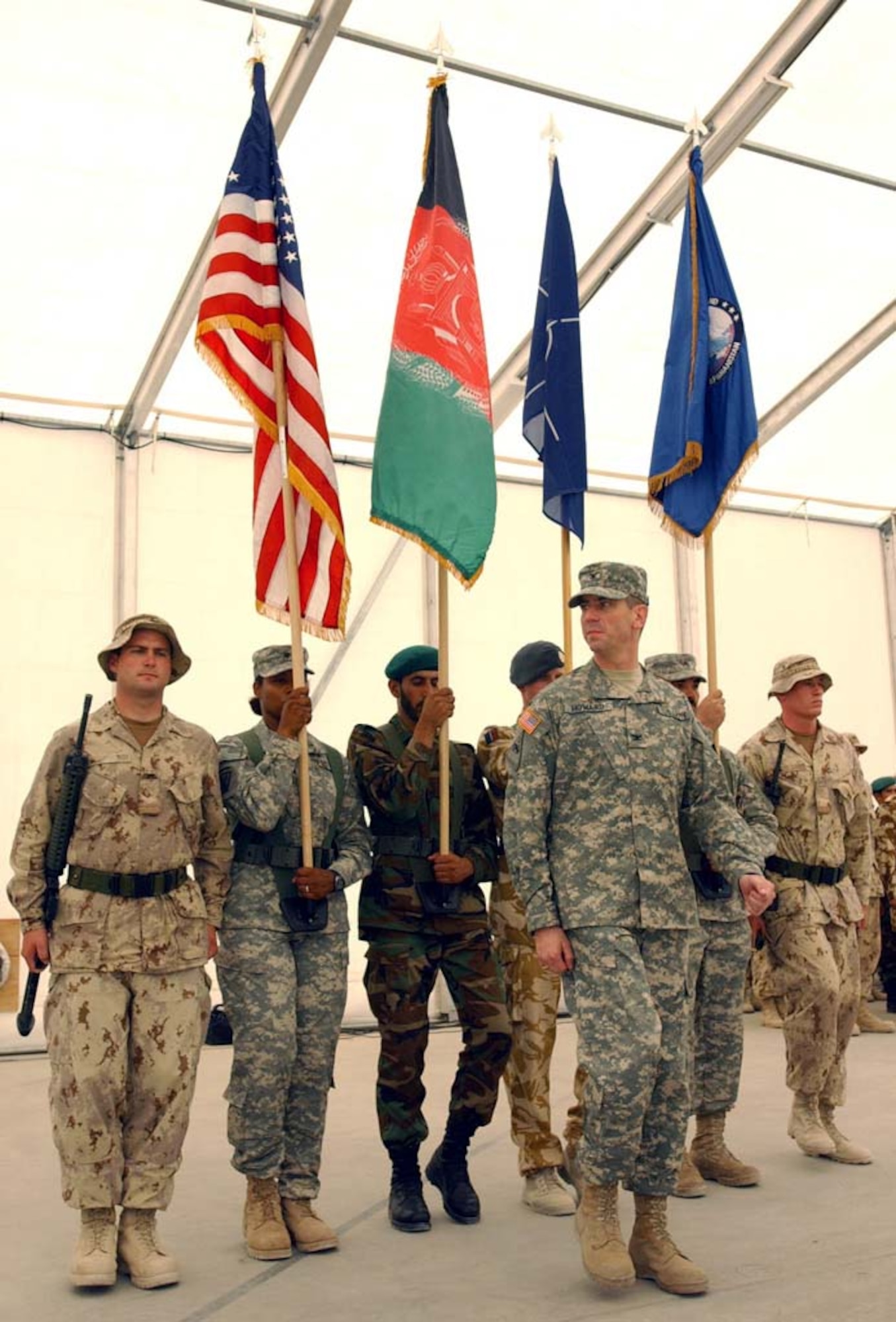 U.S. Army Col. Bart Howard presents the colors during a transfer of authority ceremony at Kandahar Airfield, Afghanistan, July 31.  Command in southern Afghanistan was transferred from Coalition forces to NATO's International Security Assistance Force during the ceremony.  Colonel Howard is the Combined Forces Command - Afghanistan chief of staff.  The color guard is a mix of Canadian, U.S., Afghan and British personnel.  (US Army photo/ Staff Sgt. Robert R. Ramon)