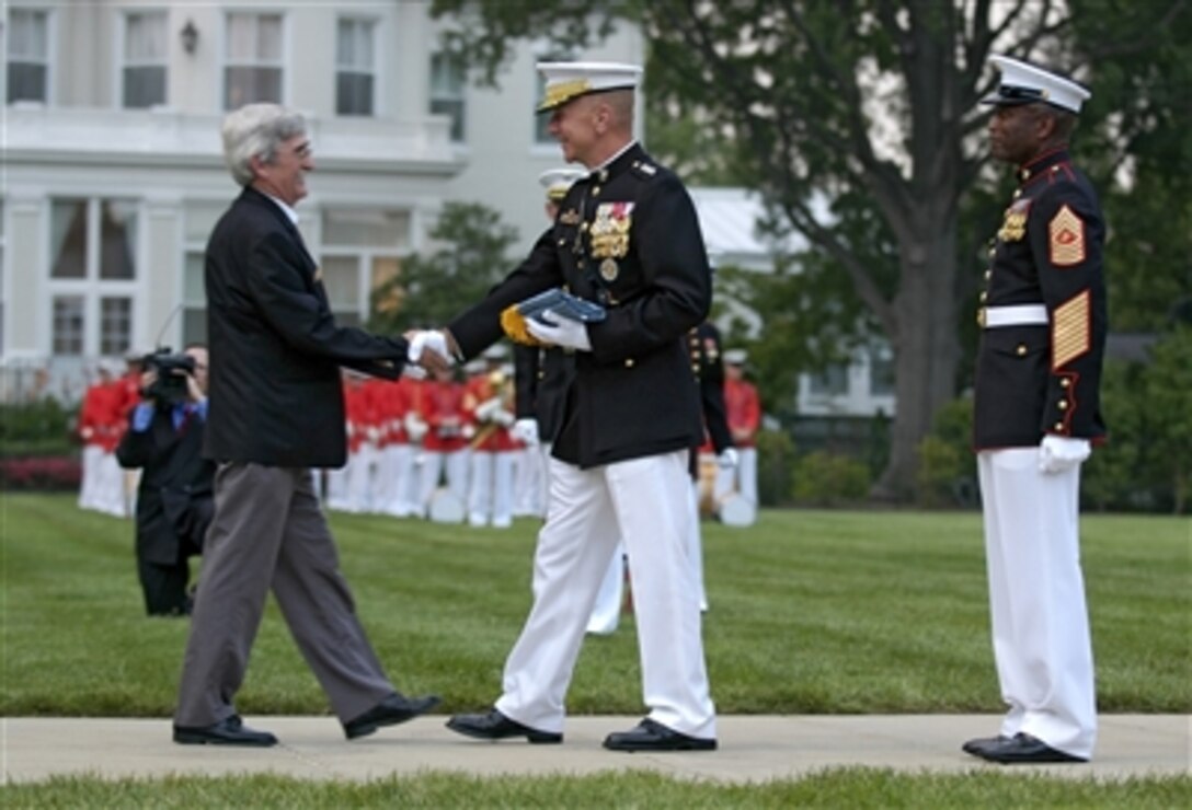 Medal of Honor recipient U.S. Marine Cpl. Robert E. O’Malley is presented with a Medal of Honor Flag by Commandant of the Marine Corps Gen. Michael W. Hagee as Sgt. Maj. of the Marine Corps John L. Estrada looks on during a parade ceremony at the Marine Barracks, 8th & I Streets, S.E., Washington, D.C., Aug. 3, 2006.