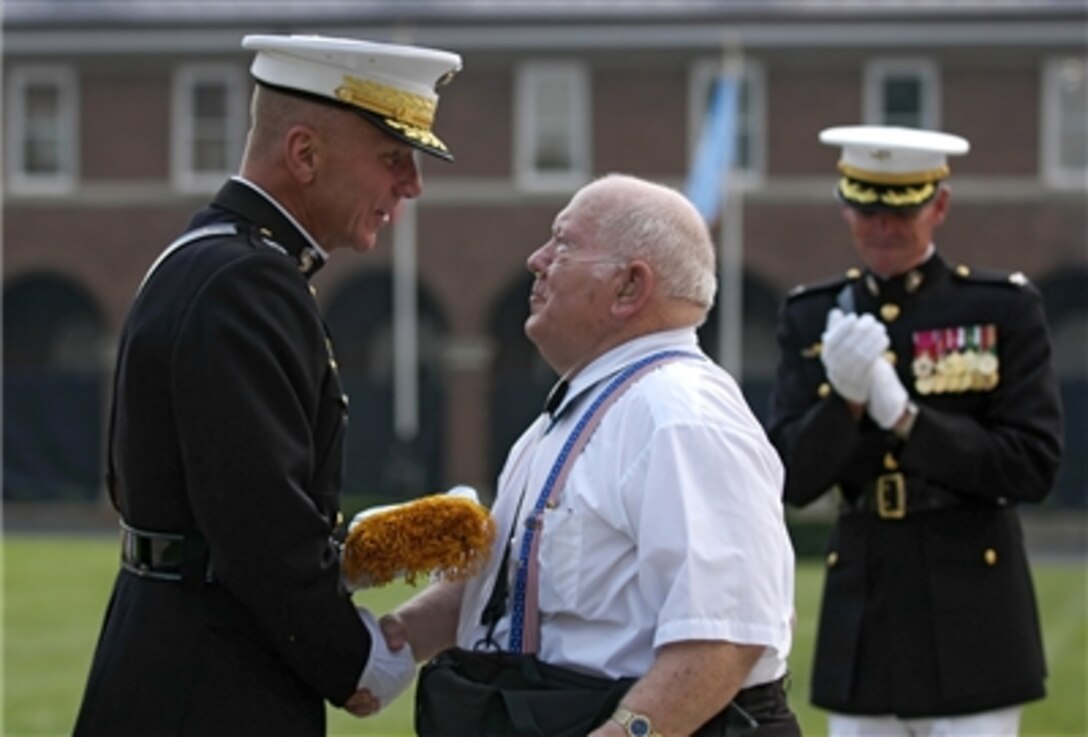 U.S. Marine Pfc. Jacklyn H. Lucas shakes hands with the Commandant of the Marine Corps Gen. Michael W. Hagee while receiving his Medal of Honor ceremonial flag during a ceremony at the Marine Barracks in Washington, D.C., Aug. 3, 2006.  
