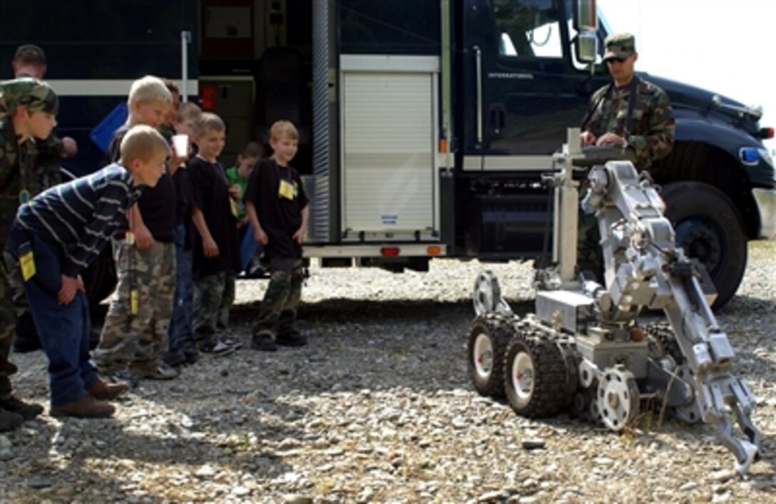 U.S. Air Force Senior Airman Steven Harris, from Explosive Ordnance Disposal Flight, Civil Engineer Squadron, shows children how the F6A Andros robot operates during Operation Bug-Out at Eielson Air Force Base, Alaska, July 29, 2006. 