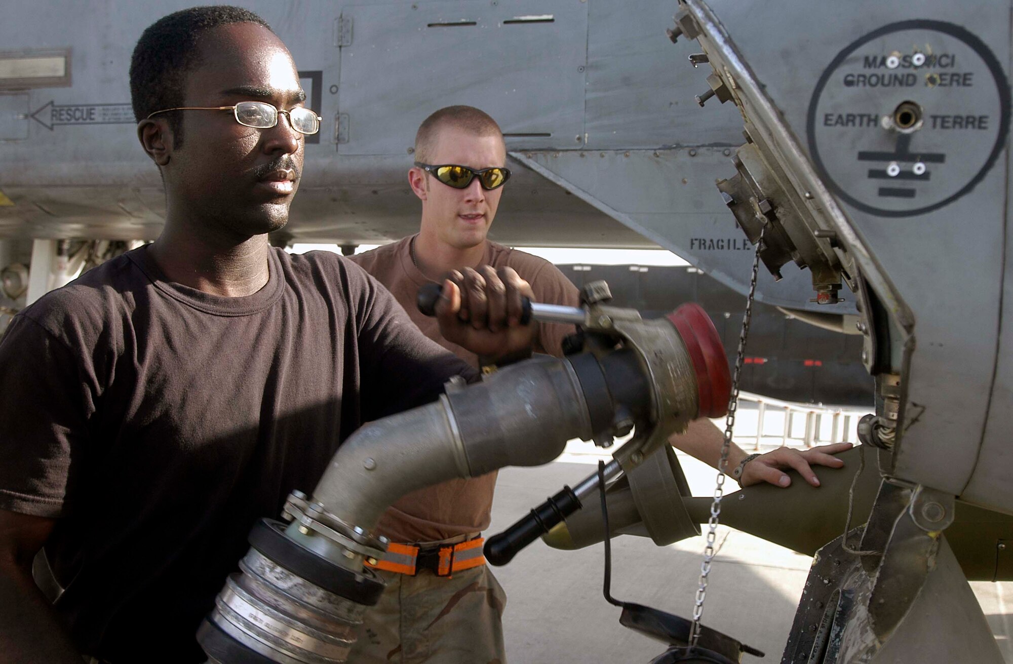 Airman 1st Class Christopher Leach, foreground, attaches a fuel hose from a tanker truck to an A-10 Thunderbolt II at Bagram Airfield, Afghanistan, Aug. 5, assisted by Airman 1st Class Perry Friend, an A-10 crew chief.  Airman Leach is the first fuels specialist in the 455th Expeditionary Logistics Readiness Squadron to pump 1 million gallons of jet fuel to aircraft at Bagram for the four-month Air Expeditionary Force one and two rotation.  The 455th ELRS Petroleum, Lubricants and Oil Flight has delivered almost 6.6 million gallons of fuel to military and civlian aircraft at Bagram since early May.  Airman Leach is deployed from the 436th Logistics Readiness Squadron at Dover Air Force Base, De.  Bagram is home to A-10s, C-130 Hercules, EA-6B Prowlers, and aircraft from the U.S. Army.  In addition to aircraft deployed here, numerous military and civilian cargo aircraft land at this base daily in support of Operation Enduring Freedom.  (US Air Force photo/Maj. David Kurle)