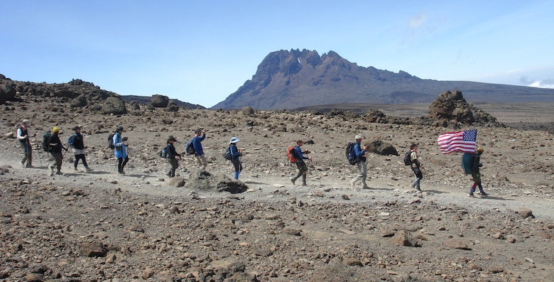 The Air Force team descends from the summit of Mount Kilimanjaro following their lead guide, Emmanuel, who is carrying the American flag. It took two guides, four assistant guides, two cooks, three servers and 30 porters to assist the team.The ascent was part of the "Seven Summits Challenge", a quest to scale the tallest peaks on all seven continents.  (U.S. Air Force photo by Capt. Rob Marshall)