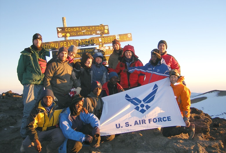 The Air Force team and some of their guides pose on the summit of Mount Kilimanjaro July 16 while holding the Air Force flag. The ascent was part of the "Seven Summits Challenge", a quest to scale the tallest peaks on all seven continents.  (U.S. Air Force courtesy photo)