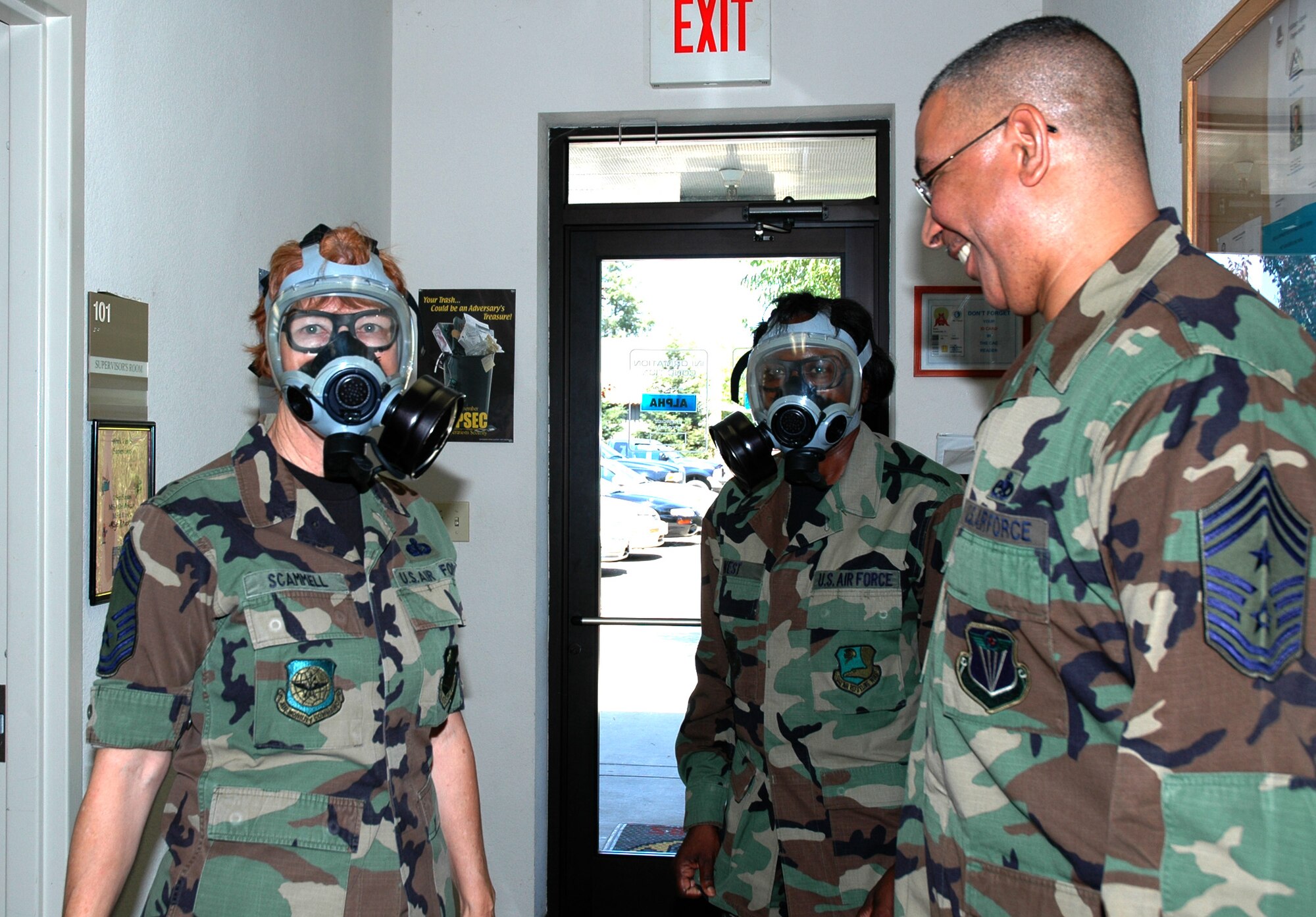 Air Force Reservist, Chief Master Sgt. Sandra Scammell, 940th Services Flight Mortuary Affairs superintendent, and Master Sgt. Joy West, 940 SVF Food Services superintendent, were practicing gas mask procedures when they met Chief Master Sgt. Kenneth Mitchell, 4th Air Force command chief, Aug. 5, 2006.  Chief Mitchell visited the 940th Air Refueling Wing at Beale Air Force Base, Calif. Aug. 5-6 to see Reservists and thank them for their service. (U.S. Air Force photo/Tech. Sgt. Brynna Bryant)