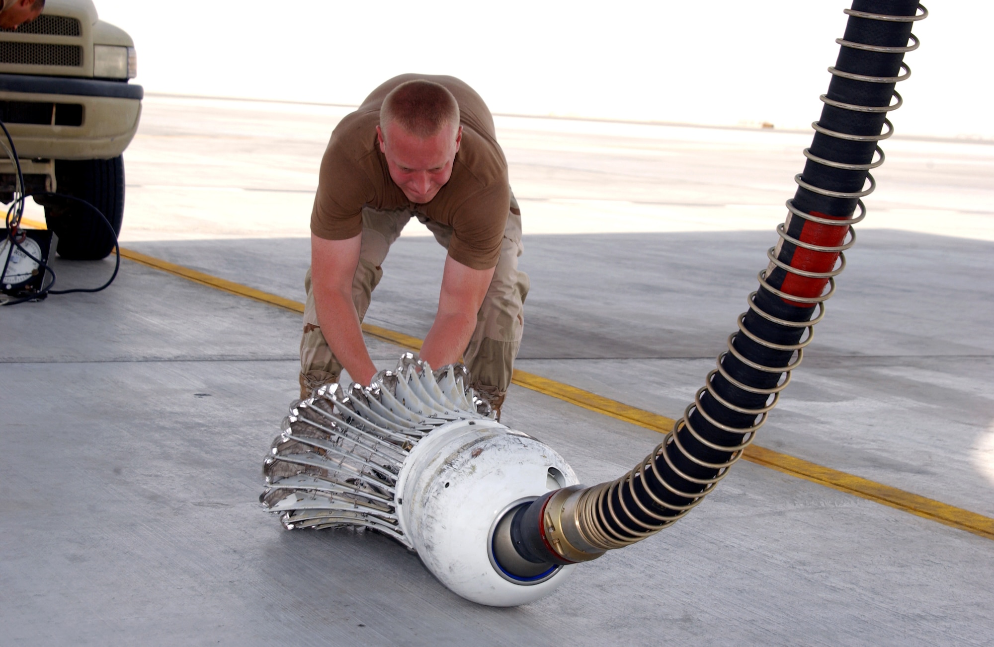 Airman 1st Class Michael Pianella prepares a drogue for a fuel pressure check at a deployed location in Southwest Asia on July 30. Airman Pianella is a hydraulics specialist with the 380th Expeditionary Aircraft Maintenance Squadron. (U.S. Air Force photo/Staff Sgt. Jason Webb) 