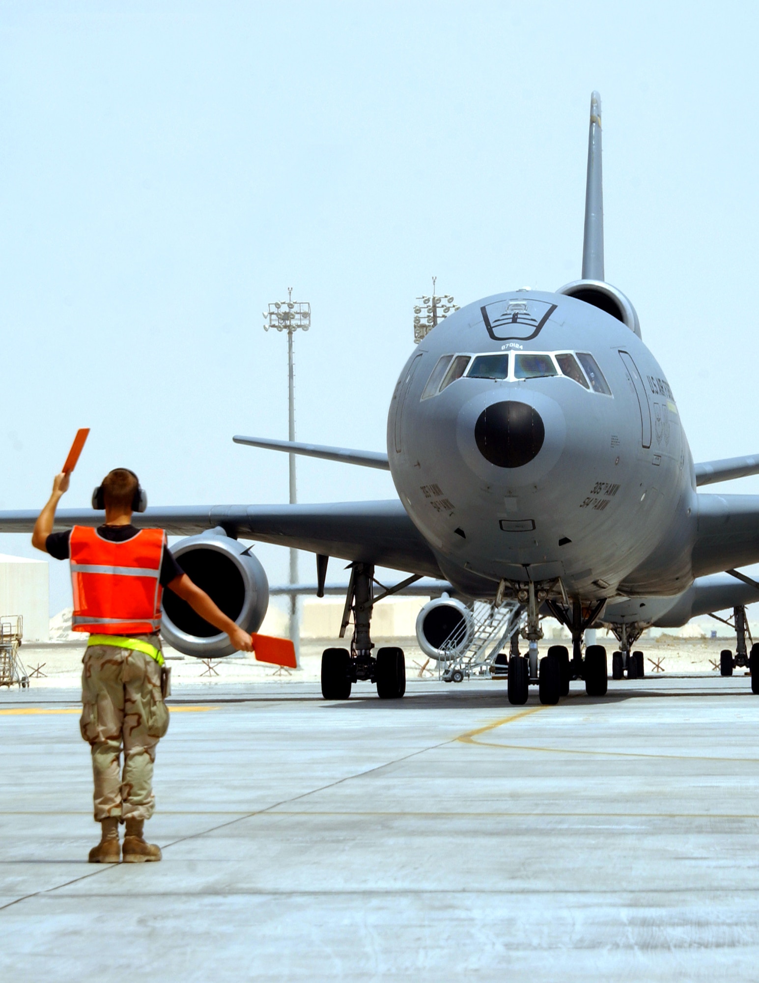 Airman 1st Class Nicholas Shoenhair marshals a KC-10 Extender to its parking spot at a deployed location in Southwest Asia. He is a KC-10 crew chief with the 380th Expeditionary Aircraft Maintenance Squadron. (U.S. Air Force photo/Staff Sgt. Jason Webb)