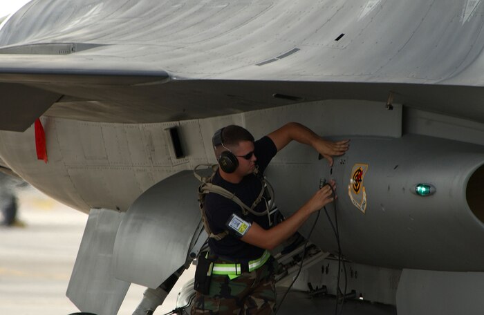 Airman 1st Class Jason Ossege, a 57th Aircraft Maintenance Squadron avionics specialist, closes the panels on an F-16 Fighting Falcon during a pre-flight inspection on the Nellis Air Force Base, Nev., flightline July 26. The 57th Wing is the largest composite wing in the Air Force. (U.S. Air Force photo/SSgt Kenny Kennemer)