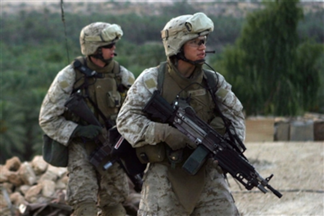 Two U.S. Marines walk down a street as they conduct a patrol in Barwanah, Iraq, on July 31, 2006.  The Marines are attached to Lima Company, 3rd Battalion, 3rd Marine Regiment, Regimental Combat Team 7, I Marine Expeditionary Force (Forward).  