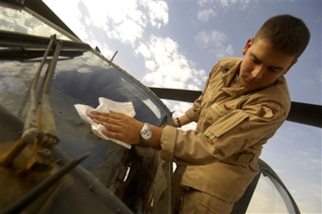 U.S. Army Spc. Cory McElhatton, a crew chief deployed to the 1st Forward Support Medical Team, cleans a UH-60A Black Hawk helicopter windshield before a mission near Tal Afar, Iraq,  Aug. 1, 2006.  McElhatton is assigned to the 542nd Medical Company (Air Ambulance), Fort Campbell, Ky. 