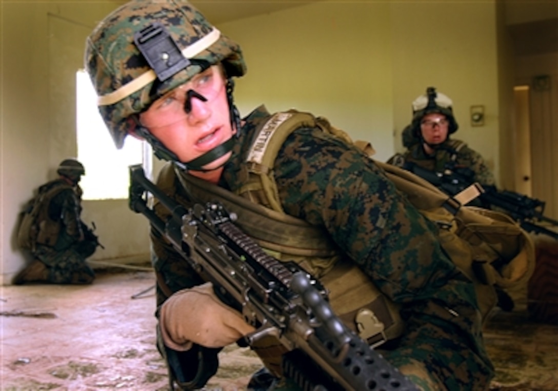 U.S. Marine Corps Pfc. Nick Martin, with Battalion Landing Team, 1st Battalion, 5th Marine Regiment, provides security as members of his squad pass through a dangerous area during urban movement drills at the former military housing complex at Anderson Air Force Base, Guam, Aug. 7, 2006.   