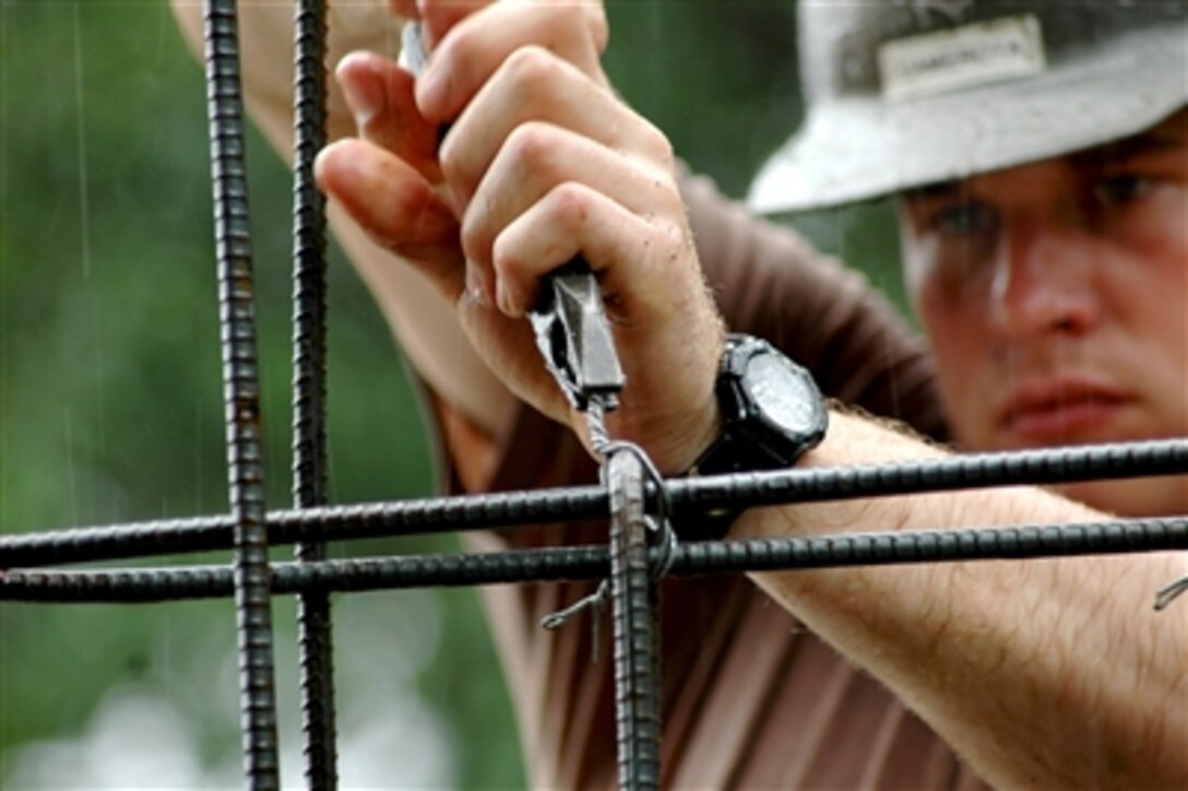Navy Seabee Petty Officer 2nd Class Armando Camerota uses pliers to tighten tie wire on reinforcing rods at the Mabanengbeng Elementary School project site in San Fernando, Philippines, on July 31, 2006.  The Seabees from Naval Mobile Construction Battalion 1 are in the Philippines to construct two classrooms for the school as part of exercise Cooperation Afloat Readiness and Training.  The exercise is an annual series of bilateral maritime training exercises between the United States and six Southeast Asian nations designed to build relationships and enhance the operational readiness of the participating forces.  