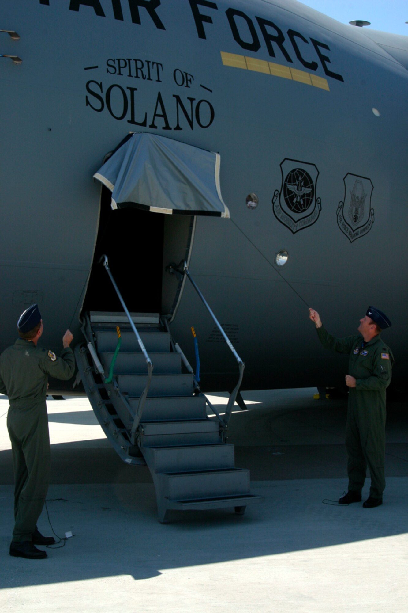 Col. Steve Arquiette, 60th Air Mobility Wing commander and Col. Robert Millmann 349 AMW acting commander, unveil the "Spirit of Solano" on Travis Air Force Base's first C-17 Globemaster III Aug. 8 as part of the arrival ceremony. The "Spirit of Solano" is the first of 13 C-17s that Travis AFB will receive, adding its tactical capabilities to Travis' mission - the strategic airlift of the C-5 and the aerial refueling of the KC-10. (Air Force photo/Master Sgt. Wendy Weidenhamer)