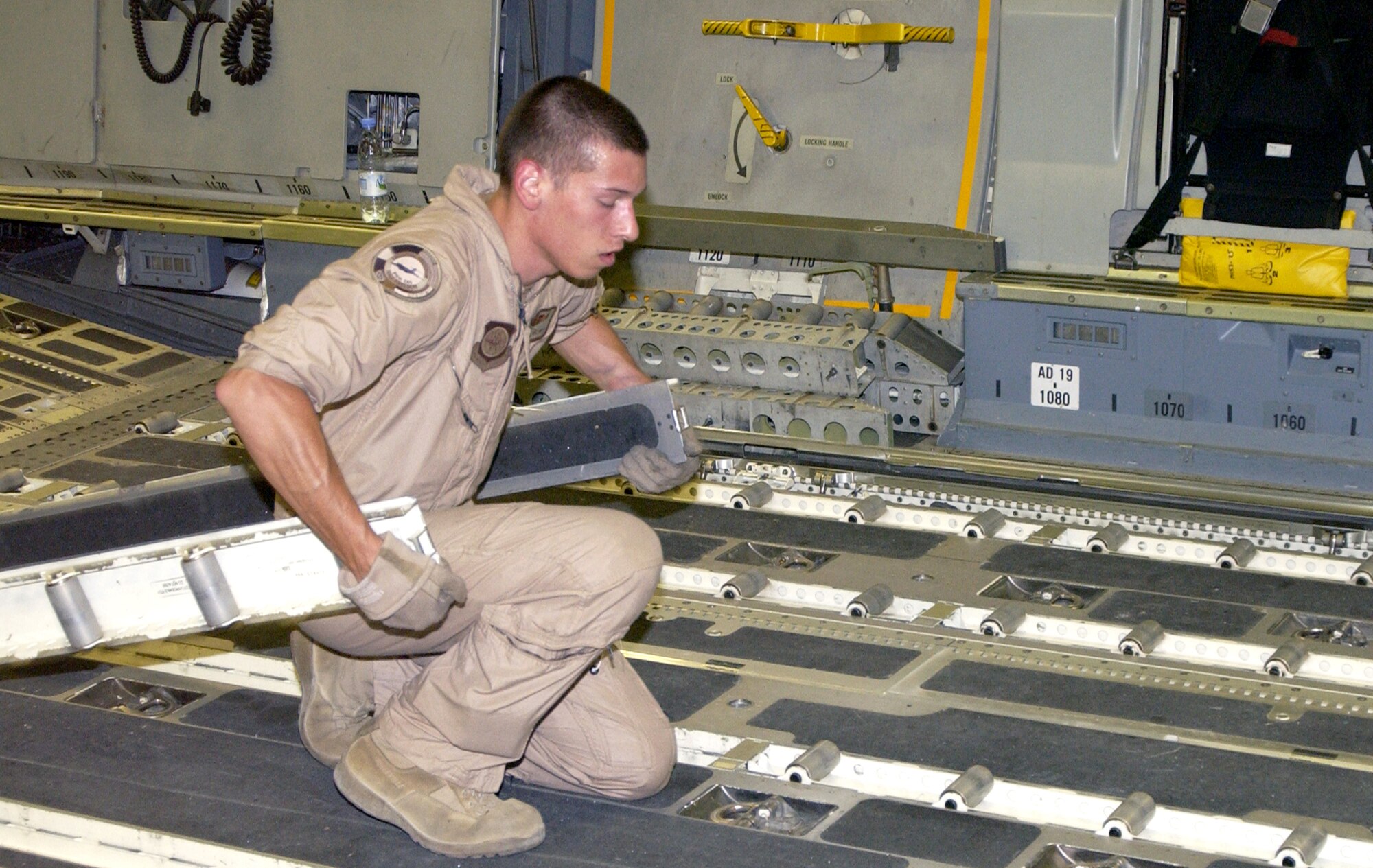 Airman 1st Class Darrick Maloney prepares the cargo floor for a full load of pallets destined for Balad Air Base, Iraq, on Aug. 5. Airman Maloney is a C-17 Globemaster III loadmaster with the 816th Expeditionary Airlift Squadron. (U.S. Air Force photo/Staff Sgt. Paul J. Gonzalez)

