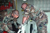 MOFFETT FEDERAL AIRFIELD, Calif. -- Air Force Reserve Technical Sergeants Paul Tatar, left, and Robert Horner, aerial spray maintenenace technicians with Air Force Reserve Command's 910th Airlift Wing, Youngstown Air Reserve Station, Ohio, install a boom nozzle bracket inside a specially-modified C-130H aircraft in support of the Safe Seas 2006 Oil Spill Response Exercise to be held in San Francisco August 9. U.S. Air Force photo/Capt. Brent Davis.