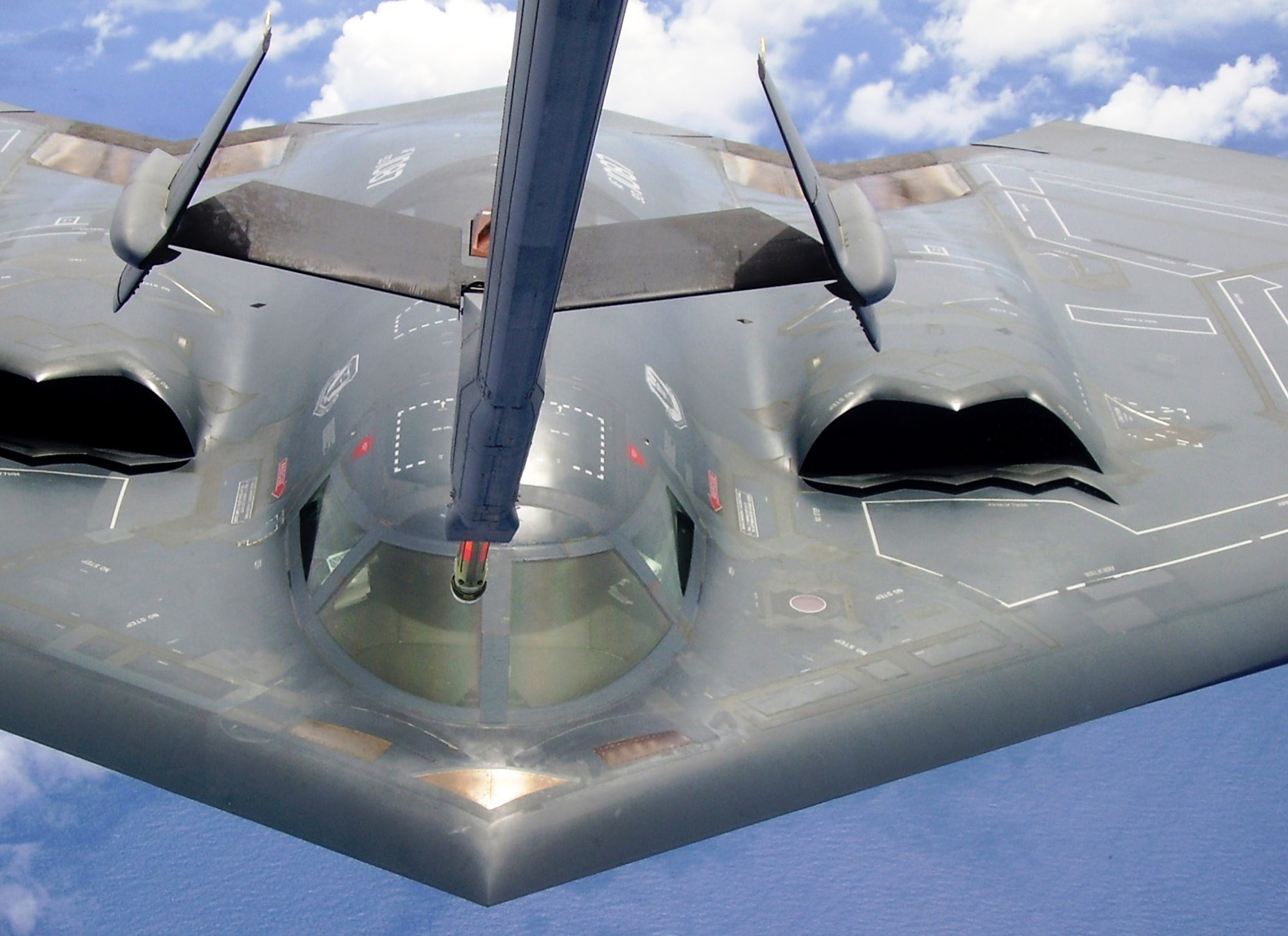 Royal Air Force Squadron Leader David Arthurton and Capt. Timothy Rezac fly a B-2 Spirit bomber as they receive fuel from a KC-10 Extender during a training mission near Andersen Air Force Base, Guam, on Aug. 2. Squadron Leader Arthurton is with the United Kingdom's Royal Air Force Personnel Exchange Program. He and Captain Rezac are with the 13th Expeditionary Bomb Squadron. (U.S. Air Force photo/Senior Airman Melissa Perry) 