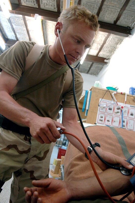 Staff Sgt. Eric Mathiasen checks an Afghan man's blood pressure during a routine medical exam inside the forward operating base clinic. Sergeant Mathiasen is a medic with the Tarin Kowt Provincial Reconstruction Team. (U.S. Air Force photo/Master Sgt. Orville F. Desjarlais Jr.) 