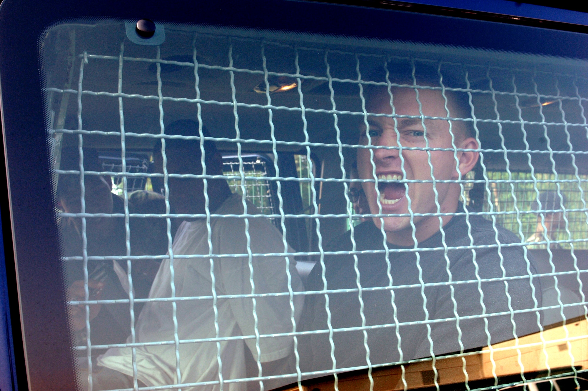 Airman 1st Class Jeffrey Alvis sits in a security forces van after being apprehended by gate guards during a confrontation managment exercise at Vogelweh Air Station, Germany, on Aug. 4. Airman Alvis is with the 569th U.S. Forces Police Squadron. (U.S. Air Force photo/Airman 1st Class Julianne Trulson)