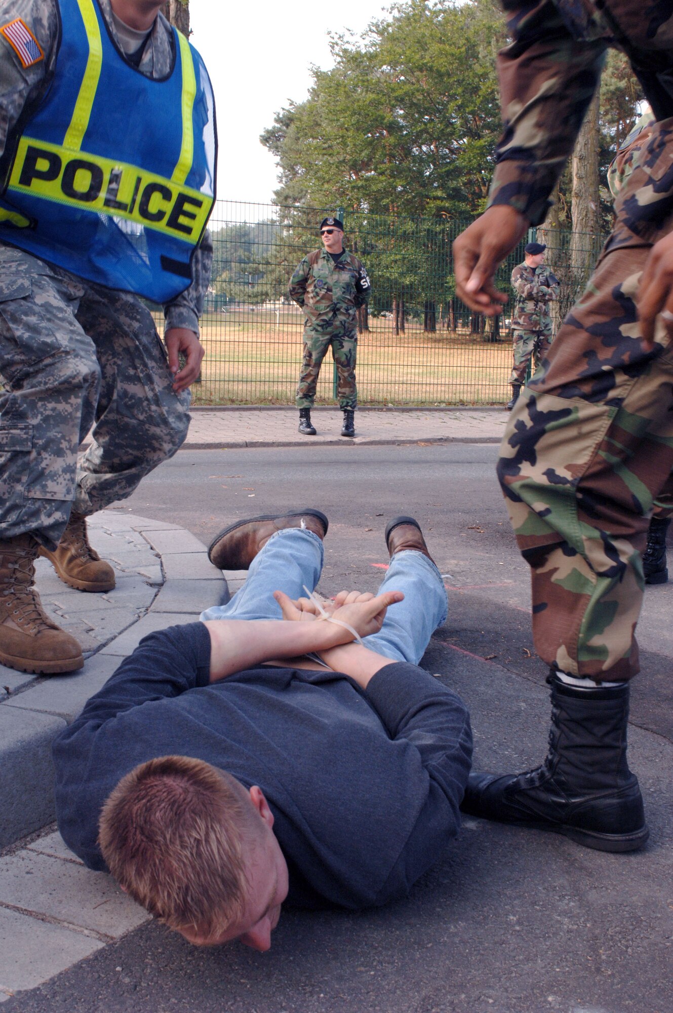 Airman 1st Class Jeffrey Alvis is cuffed on the ground with zip-ties by Senior Airman Xavier Drake during a confrontation managment exercise at Vogelweh Air Station, Germany, on Aug. 4. The Airmen are with the 569th U.S. Forces Police Squadron. (U.S. Air Force photo/Airman 1st Class Julianne Trulson)