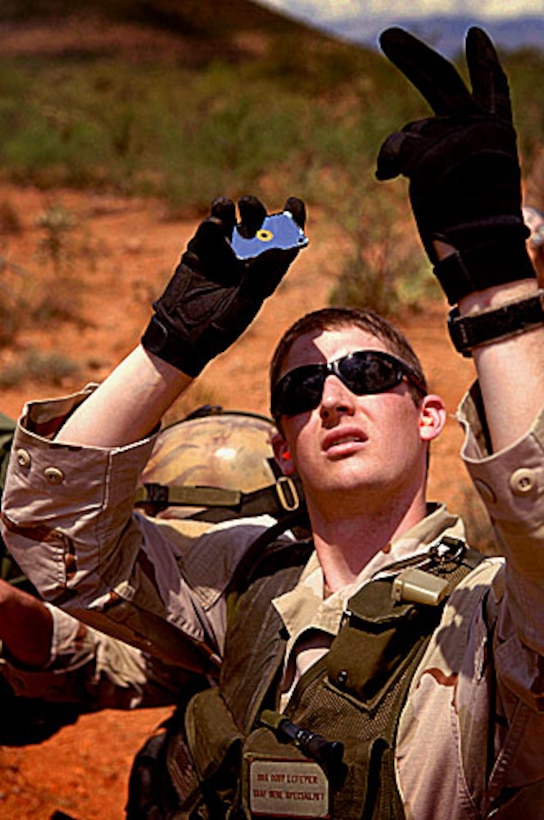 U.S. Air Force Senior Airman Cody Lefever uses a signaling mirror to alert the pilots of an A-10 Thunderbolt II aircraft during a recovery scenario for exercise Angel Thunder outside Davis-Monthan Air Force Base, Ariz., July 26, 2006.  Lefever is an Air Force Survival Evasion Resistance Escape specialist.  