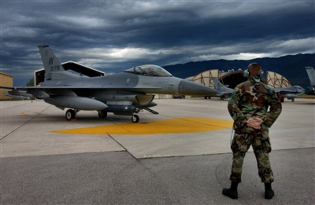 U.S. Air Force Senior Airman Craig Burdge waits for a signal from the pilot of an F-16 Fighting Falcon to remove chalks prior to directing the aircraft out to the runway at Aviano Air Base, Italy, on Aug. 4, 2006.  Burdge is attached to the 31st Aircraft Maintenance Squadron.  