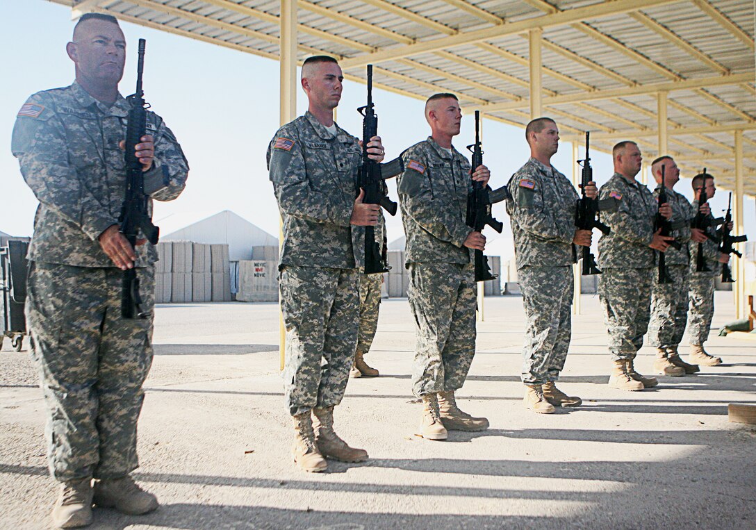 Soldiers perform a rifle salute at the end of Army Sgt. Dustin D. Laird?s memorial, which took place August 8, 2006 at Camp Taqaddum?s Mainside Chapel.  Laird, a crane operator with 913th Engineer Company, 46th Engineer Combat Battalion,  was killed August 2, 2006, while conducting combat operations in the city of Fallujah. The Union City, Tenn., native was remembered as a courageous and often comedic individual, who raised the morale within his unit.