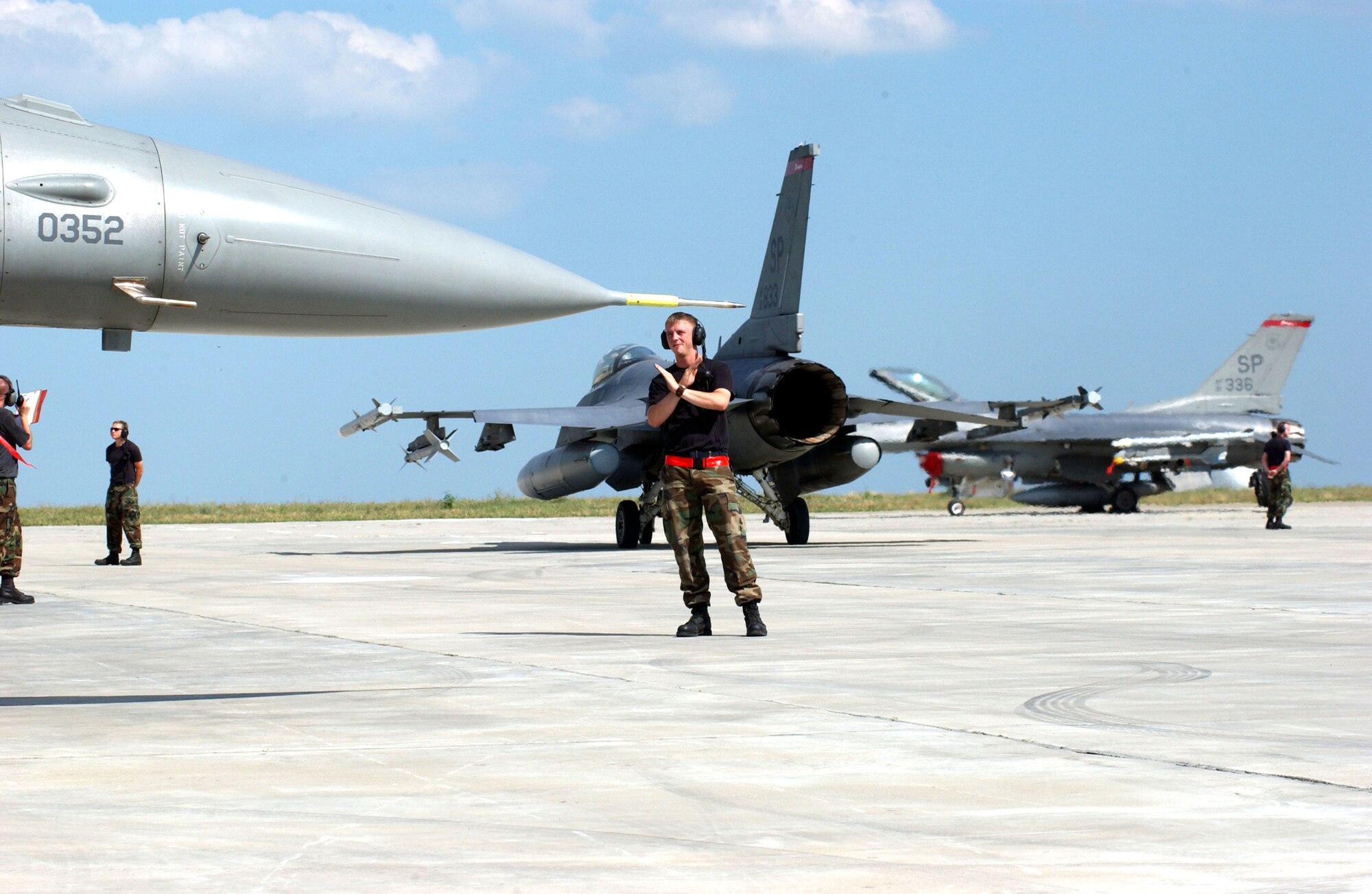 Senior Airman Steven Weidman marshals an F-16 Fighting Falcon before its first mission against the Romanian Air Force's MiG 21 Lancers at Exercise Viper Lance 2006 at Mihail Kogalniceanu Air Base, Romania, on Aug. 9. This is the first time F-16 crews have trained in Romania. Airman Weidman is a crew chief with the 22nd Expeditionary Fighter Squadron. The F-16 is from Spangdahlem Air Base, Germany. (U.S. Air Force photo/Senior Airman Eydie Sakura) 

