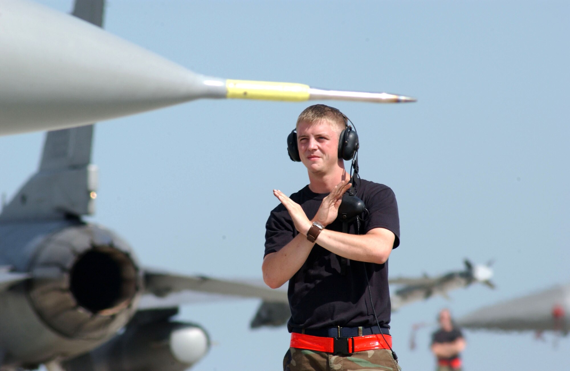 Senior Airman Steven Weidman marshals an F-16 Fighting Falcon before its first mission against the Romanian Air Force's MiG 21 Lancers at Exercise Viper Lance 2006 at Mihail Kogalniceanu Air Base, Romania, on Aug. 9. This is the first time F-16 crews have trained in Romania. Airman Weidman is a crew chief with the 22nd Expeditionary Fighter Squadron. The F-16 is from Spangdahlem Air Base, Germany. (U.S. Air Force photo/Senior Airman Eydie Sakura) 
