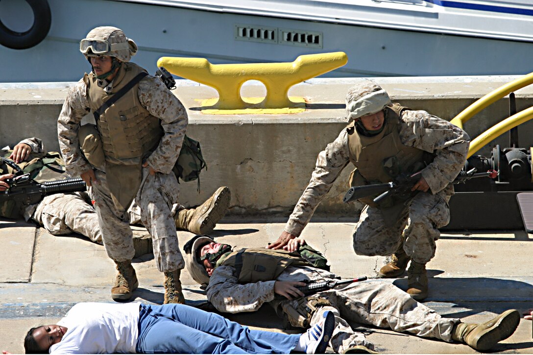 NAVAL BASE SAN DIEGO (Aug. 9, 2006) -- Cpl. Vic B. Madrillejos, infantry squad leader, and Lance Cpl. Armando Avila, infantry assault man,  assess injured Marines and civilians during a Force Protection Exercise on Pier 8. Madrillejos, a native of Sacramento, Calif., and Avila, a native of Houston, are Marines with Echo Co., Battalion Landing Team 2/4, which is attached to the 15th Marine Expeditionary Unit. The main purpose of this exercise was for the Expeditionary Strike Group 5 and the 15th MEU to practice different force protection levels, pier security, stability, and to work together to maximize their unit capabilities.  (Official USMC photo by Cpl Thomas J. Grove) (Released)
