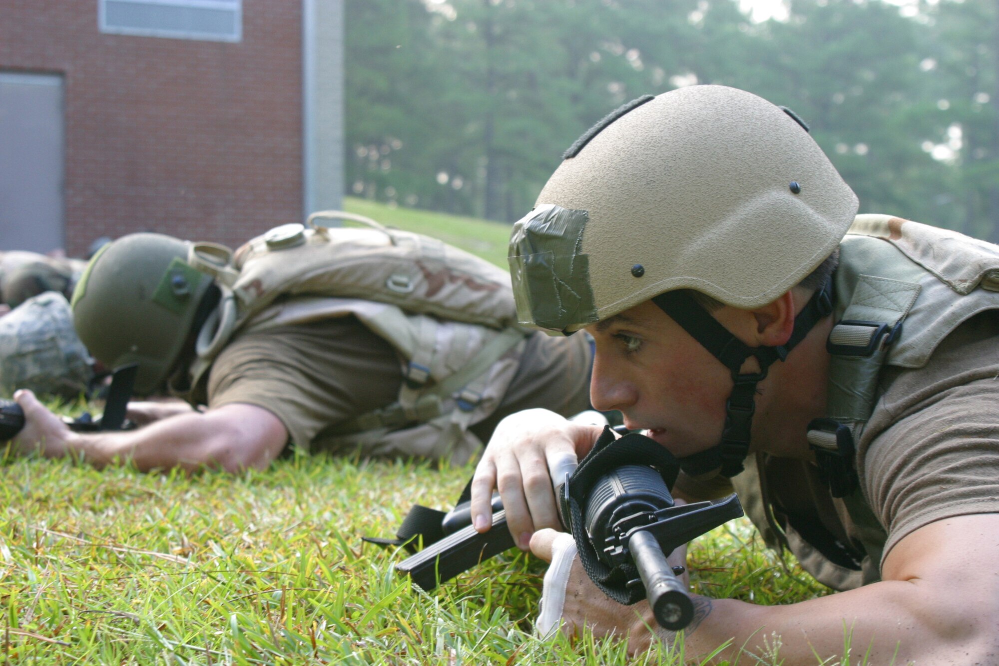Airman 1st Class Thomas Gunnell, 18th Air Support Operations Squadron tactical air control party, low crawls with his weapon in a simulated hostile fire scenario during the close combat instruction course Monday. (U.S. Air Force photo/ Senior Airman Stacia Zachary)