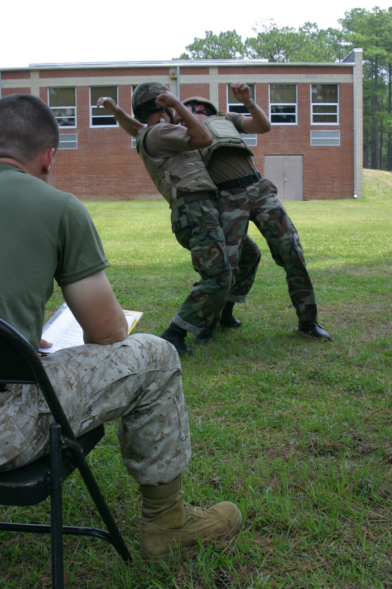 Marine Corps Sgt. Steve Redman, Martial Arts Center of Excellence instructor, oversees and assesses Tech. Sgt. J. Gaona, 18th Weather Squadron combat weatherman, deflecting a counter reverse headlock from Senior Airman Thomas Gunnell, 18th ASOG tactical air control party Airman, during the 10-day Close Combat Instruction designed for Air Force special forces. (U.S. Air Force photo/ Senior Airman Stacia Zachary)