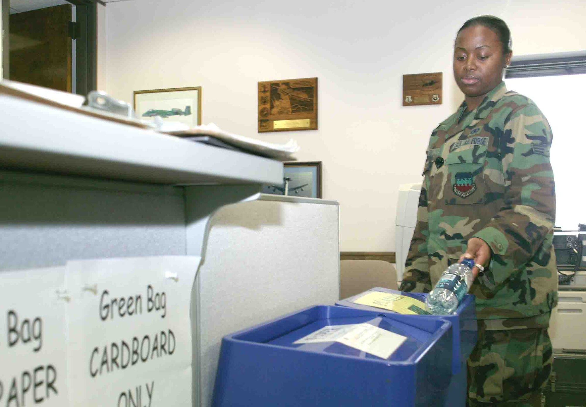 Senior Airman Shaketheia Hinton, 20th Fighter Wing client system administrator, drops her water bottle in the plastic recycle bin. (U.S. Air Force photo/Senior Airman John Gordinier)