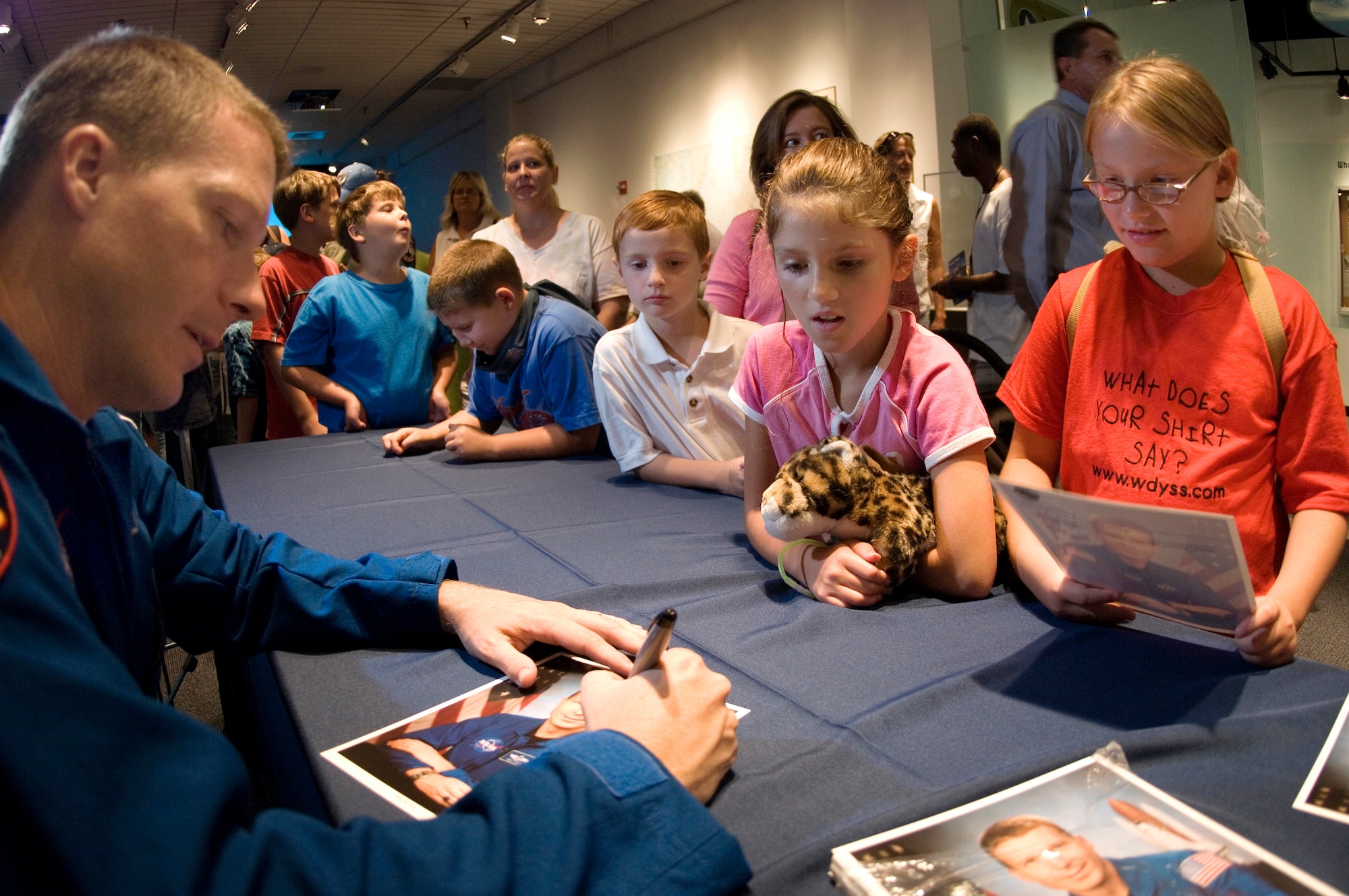 Lt. Col. Terry Virts Jr., a NASA astronaut, signs pictures at the St. Louis Science Center on Aug. 9. Colonel Virts spoke to children about the Air Force and his career as an astronaut. The event was one of several activities taking place in the greater St. Louis area celebrating Air Force Week. (U.S. Air Force photo/Master Sgt. Jack Braden)
