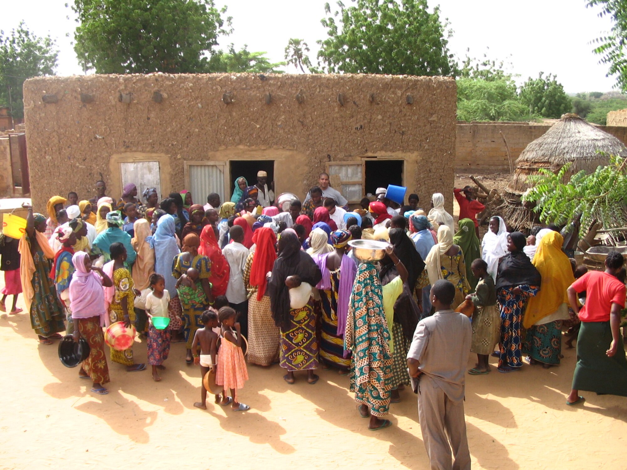 Village people from Karadje, Niger, gather around members from the 787th Air Expeditionary Squadron in July as the Ramstein-based Airmen pass out 1,000 pounds of rice they purchased from their own pockets.  The 14-person team is deployed to Niger in support of Eagle Vision, a mission to download satellite imagery for map-making purposes.  
