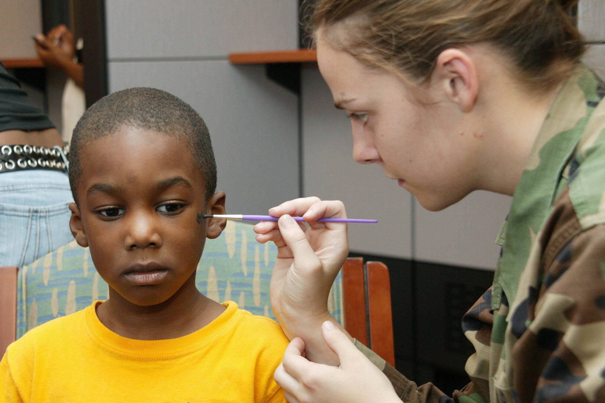 Jalen, son of Latoya and Staff Sgt. DeMario Simmons, 20th Security Forces Squadron, gets his face painted by Airman 1st Class Shea Powell, 20th Medical Operations Squadron, at the Pediatric Health Fair Aug. 4. The health fair included school sports physicals and health and safety information. (U.S. Air Force photo/Tarsha Storey)